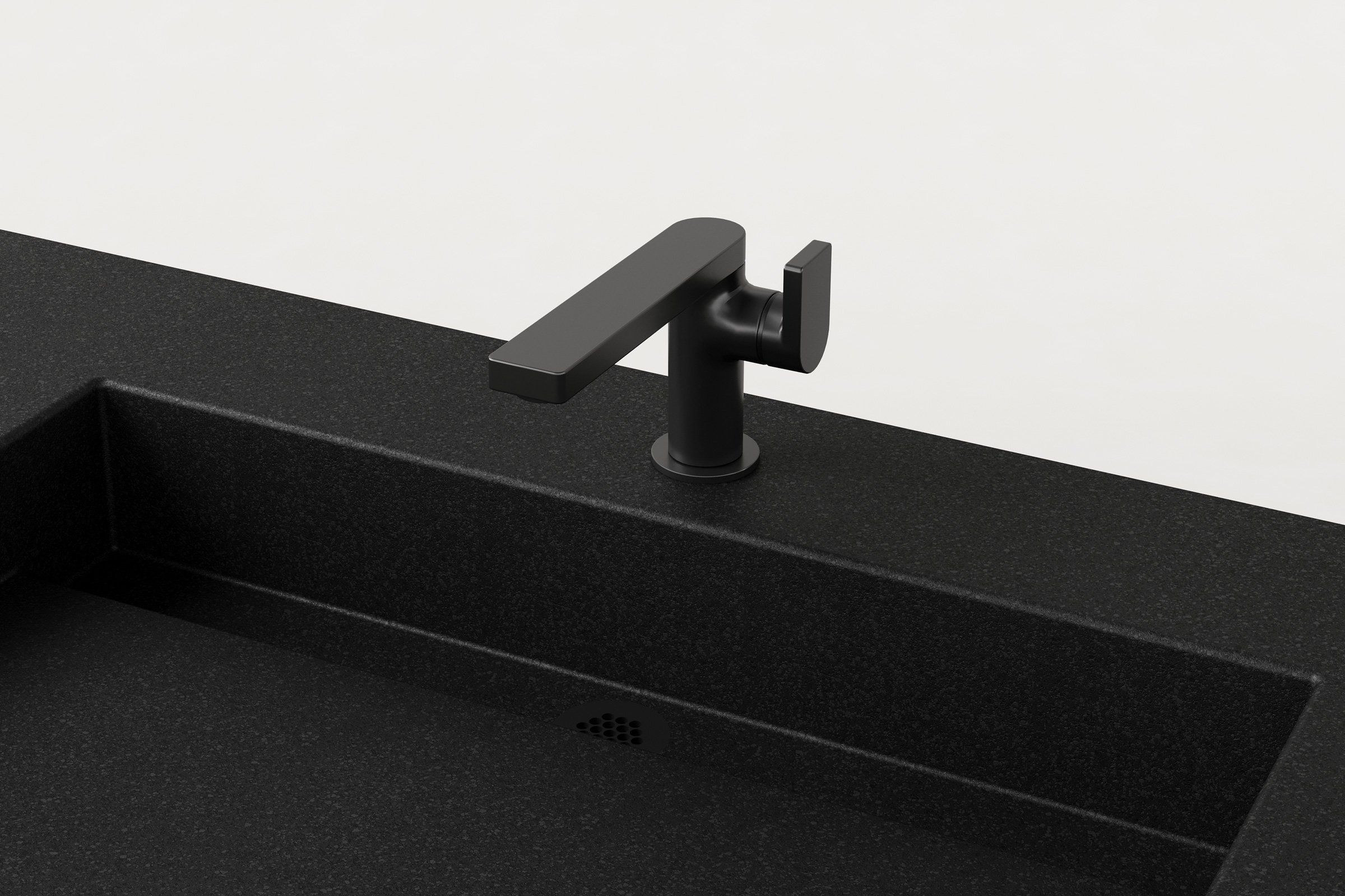 Close-up of matte black faucet installed on a black concrete double sink basin.