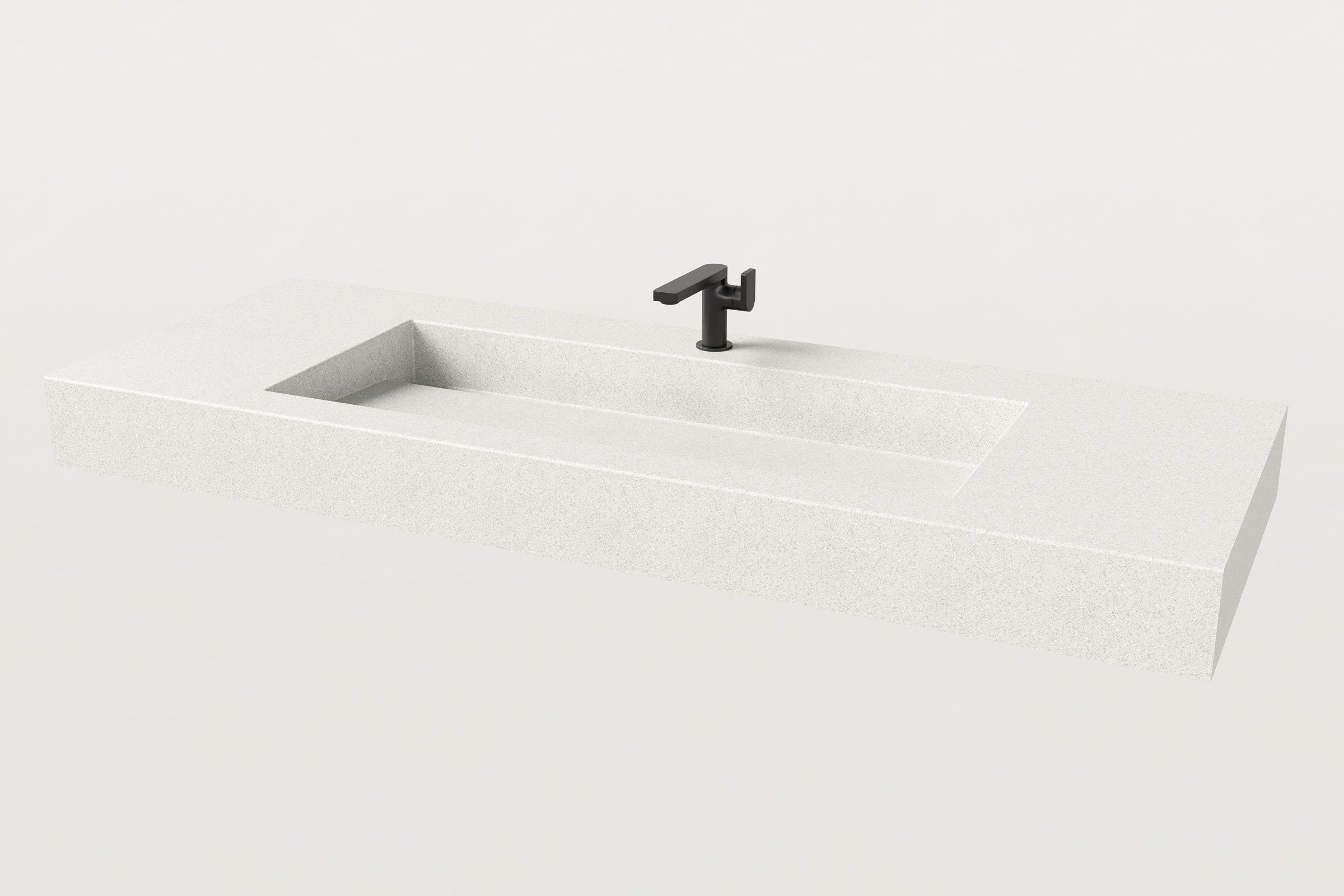Angled view of the Trof Drop 60 Chalk sink by Manos, showing its streamlined rectangular concrete form and sloped basin for ADA accessibility.