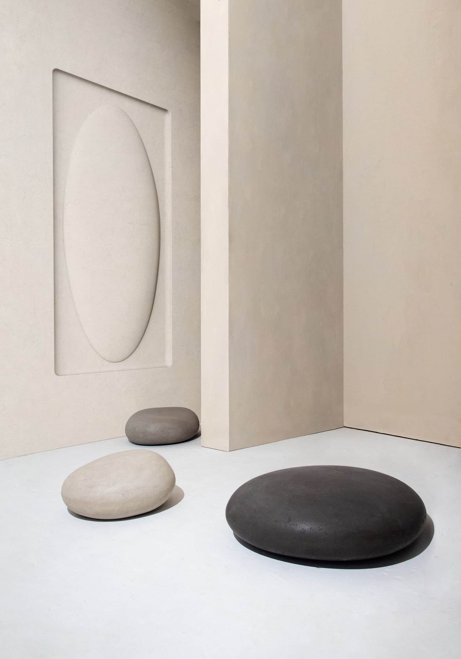 Minimalist interior with oval wall recess and three Soma Stones