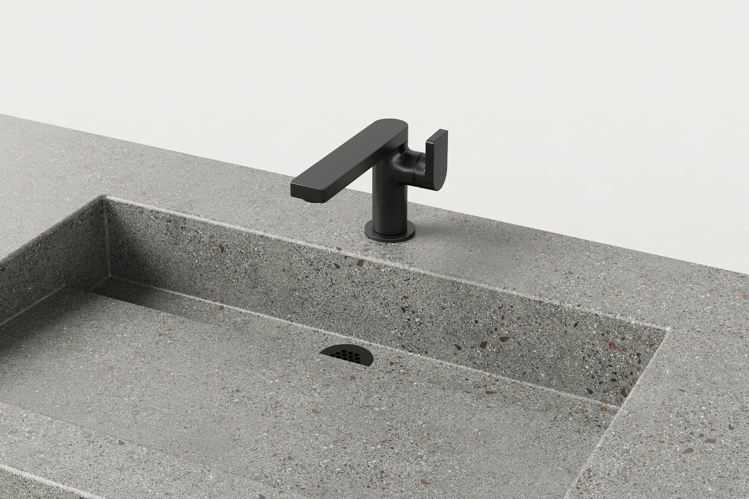 Close-up of matte black faucet mounted on Manos Trof Drop 48 concrete sink in Juda finish with integrated drain.
