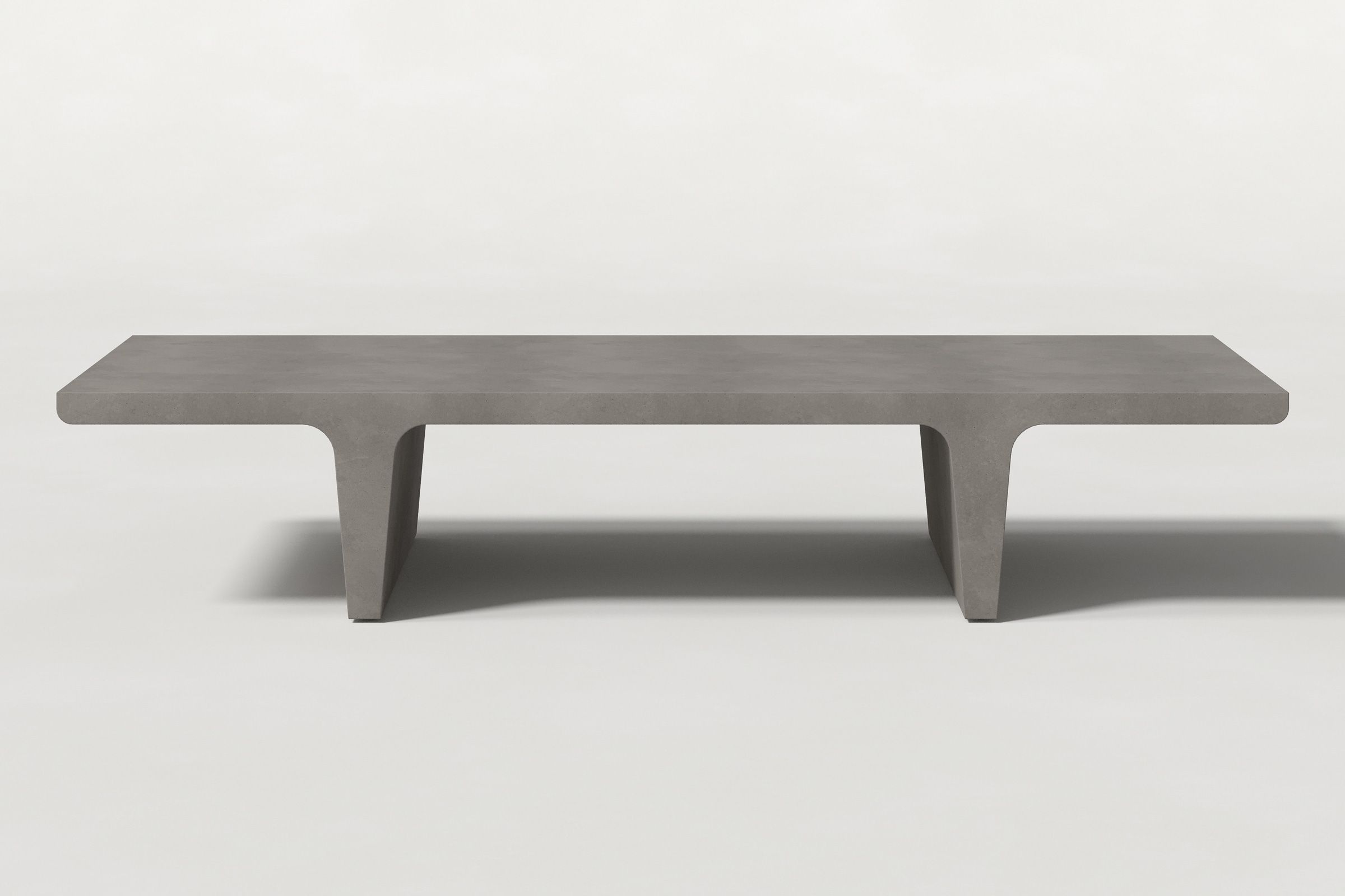 Rectangular solid dark grey concrete coffee table with sculptural double tee legs and a smooth top, set against a clean white background.