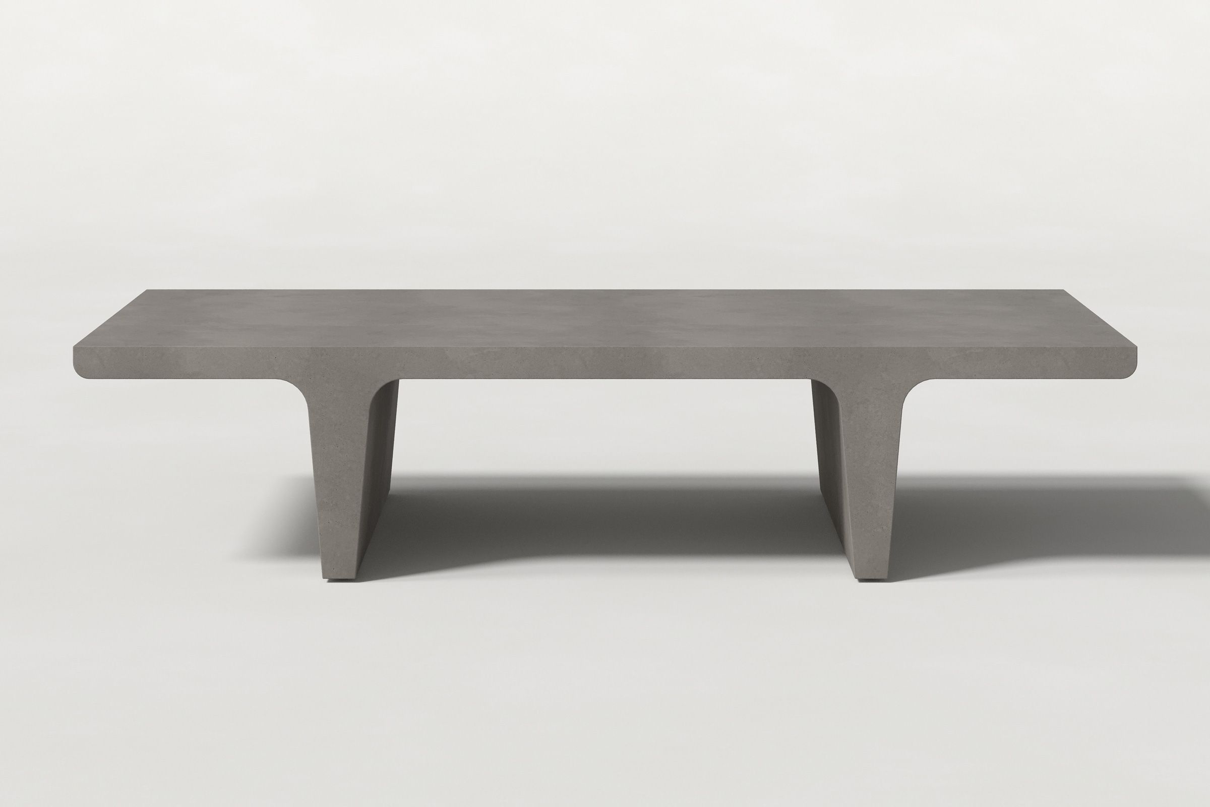 Rectangular solid dark grey concrete coffee table with sculptural double tee legs and a smooth top, set against a clean white background.