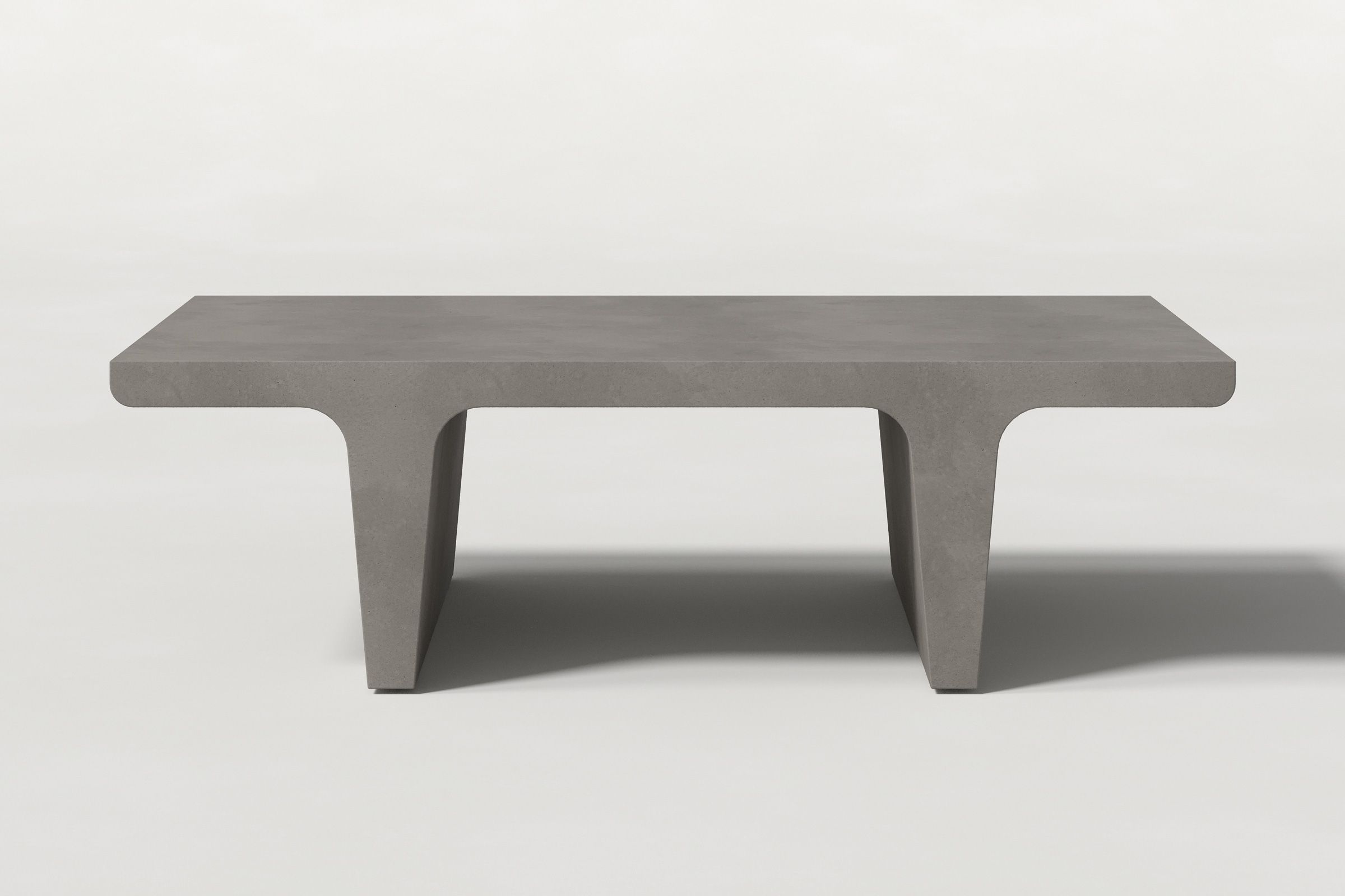 Rectangular solid dark grey concrete coffee table with sculptural double tee legs and a smooth top, set against a clean white background.