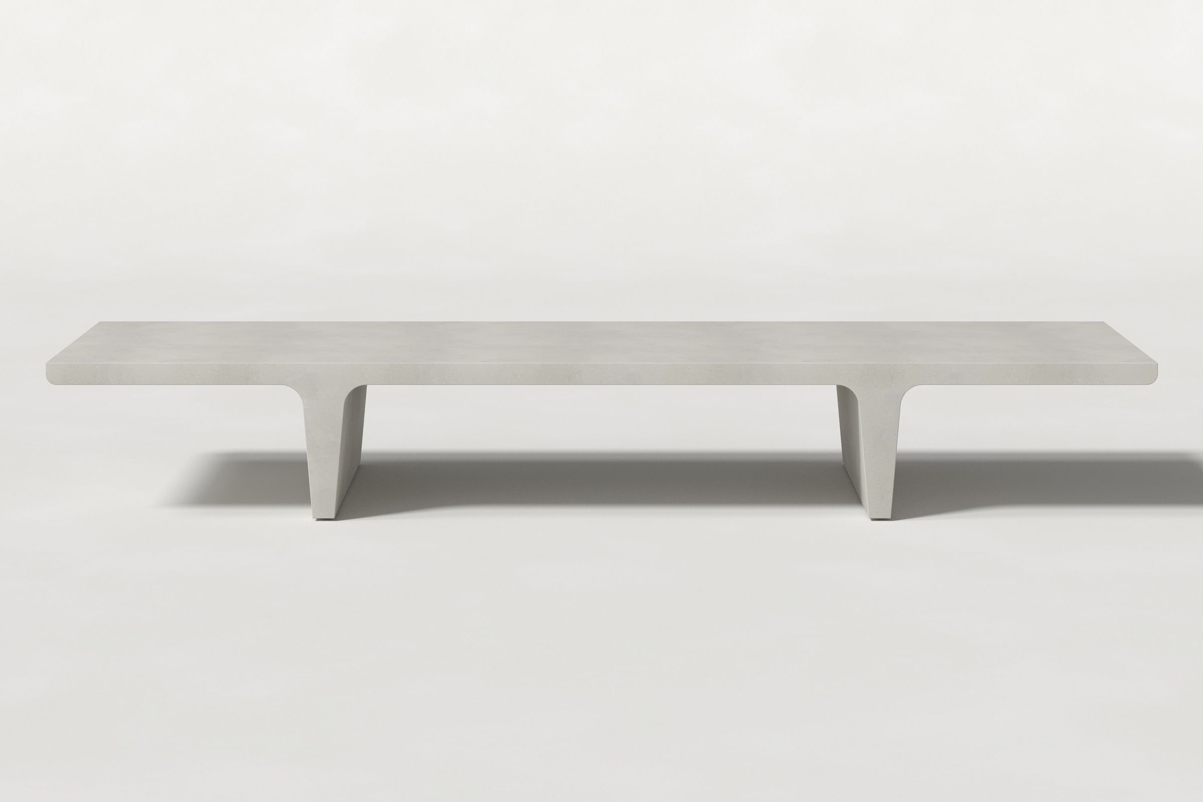 Long rectangular solid light grey concrete coffee table with sculptural double tee legs and a smooth top, set against a clean white background.