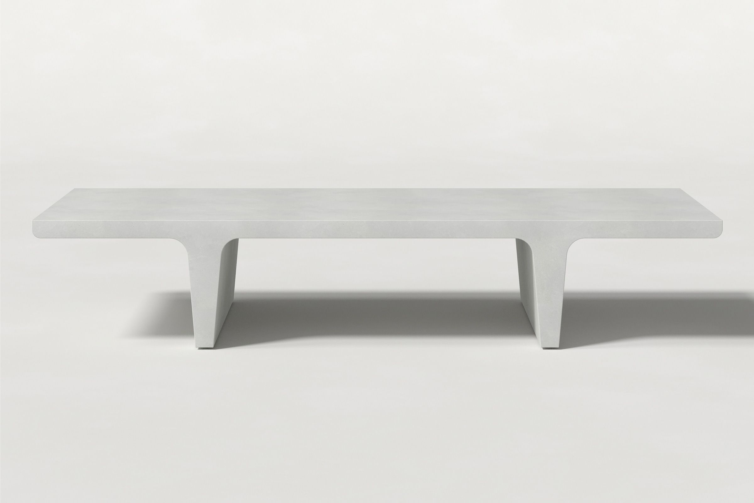 Rectangular solid white concrete coffee table with sculptural double tee legs and a smooth top, set against a clean white background.