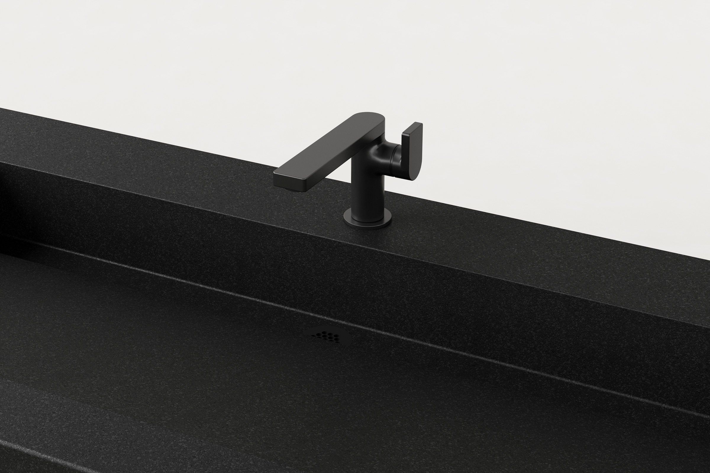 Close-up of the matte black faucet and integrated triangular drain detail within the black concrete basin.