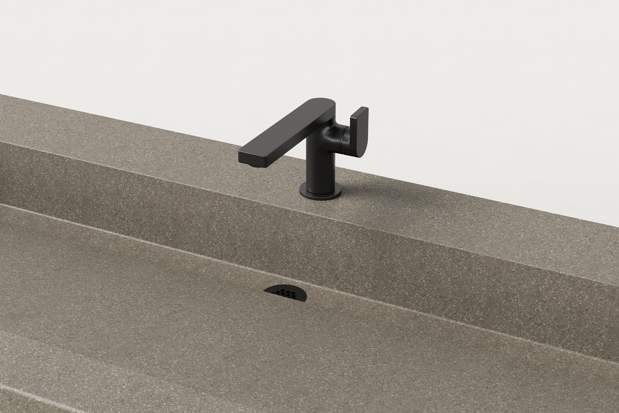 Close-up of the black faucet and half-moon slot drain of the taupe-grey concrete sink, showing the fine texture of the concrete surface.