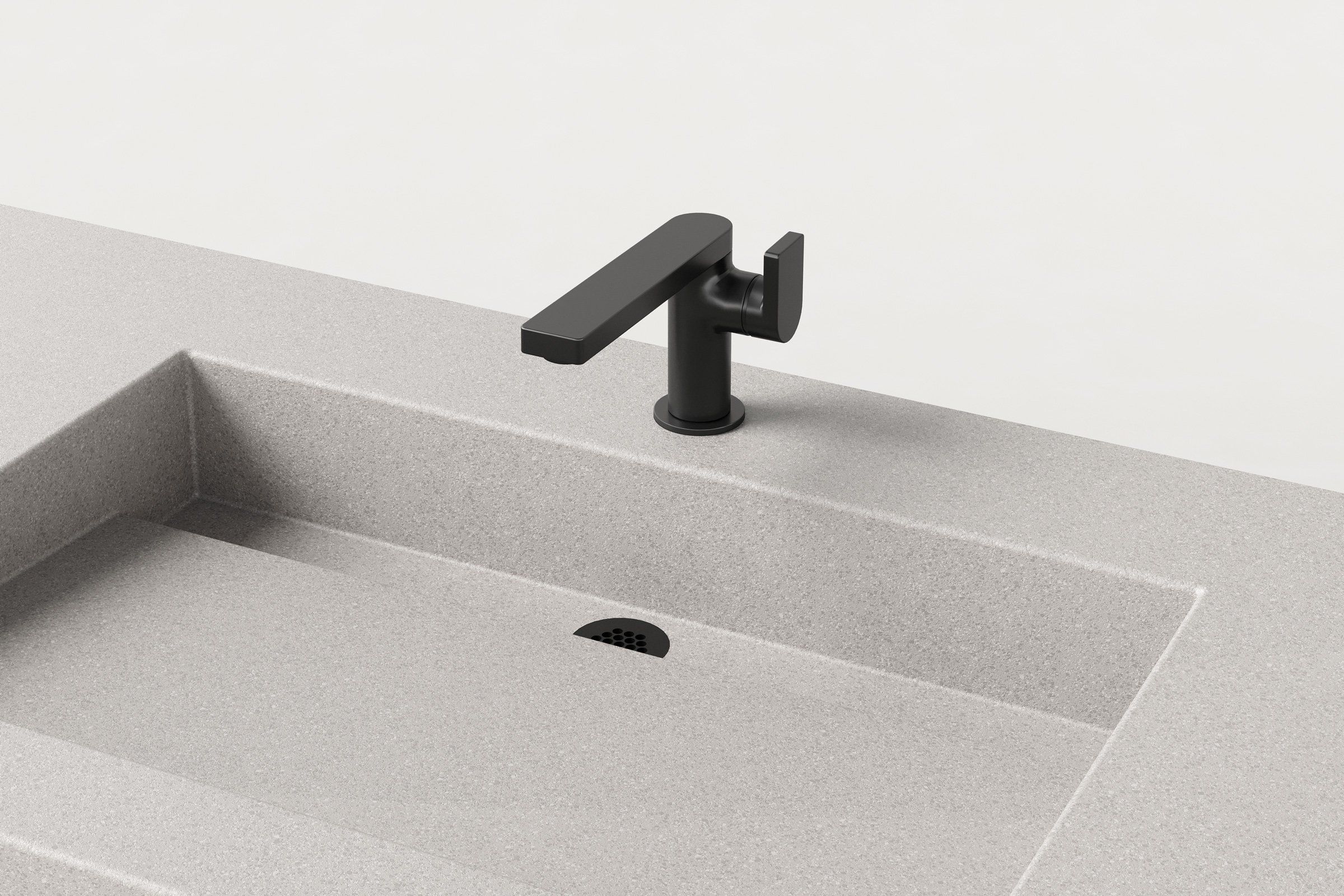 Close-up of matte black faucet mounted on Manos Trof Drop 48 concrete sink in Chalk finish with integrated drain.