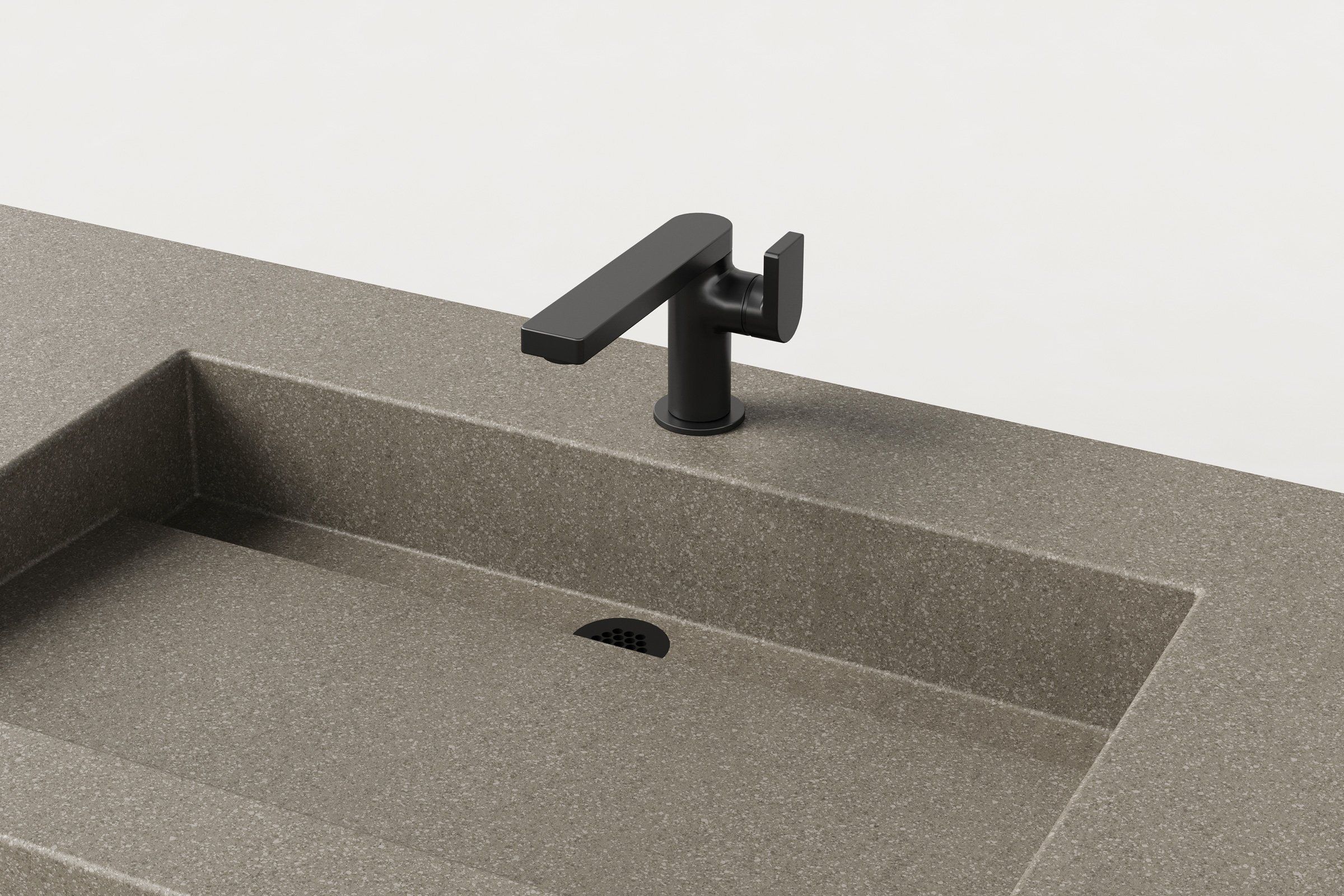 Close-up of matte black faucet mounted on Manos Trof Drop 48 concrete sink in Hurricane finish with integrated drain.