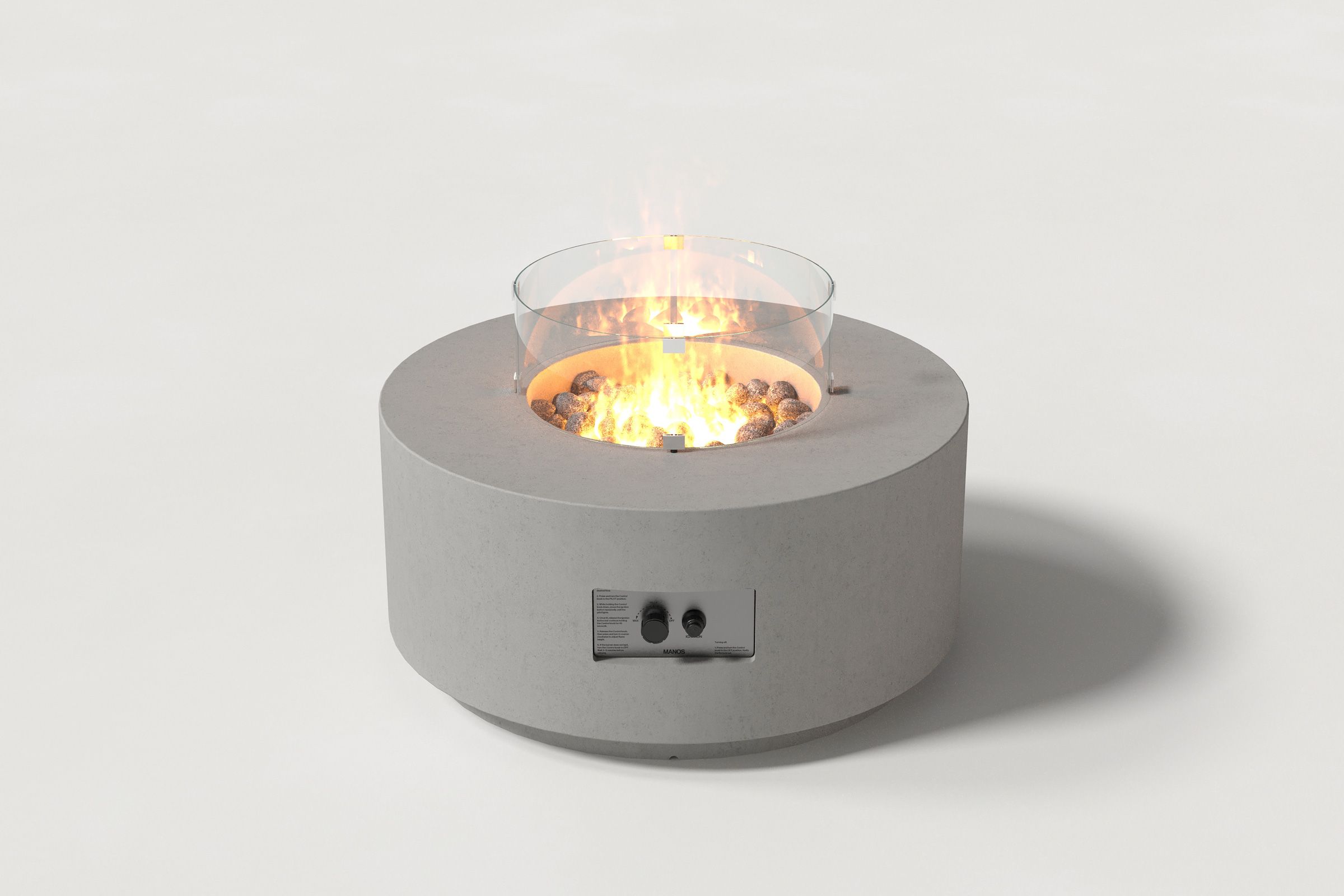 Low cylindrical grey colored concrete fire pit with thick walls and a central circular well filled with dark volcanic rocks and flame, featuring an integrated control panel and glass shield. Front view on a white background.