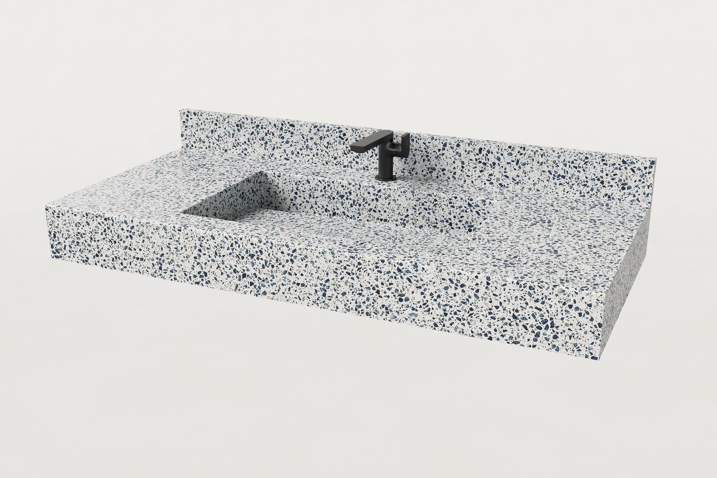 Angled view of terrazzo sink in Unazzo finish with matching backsplash and black faucet.