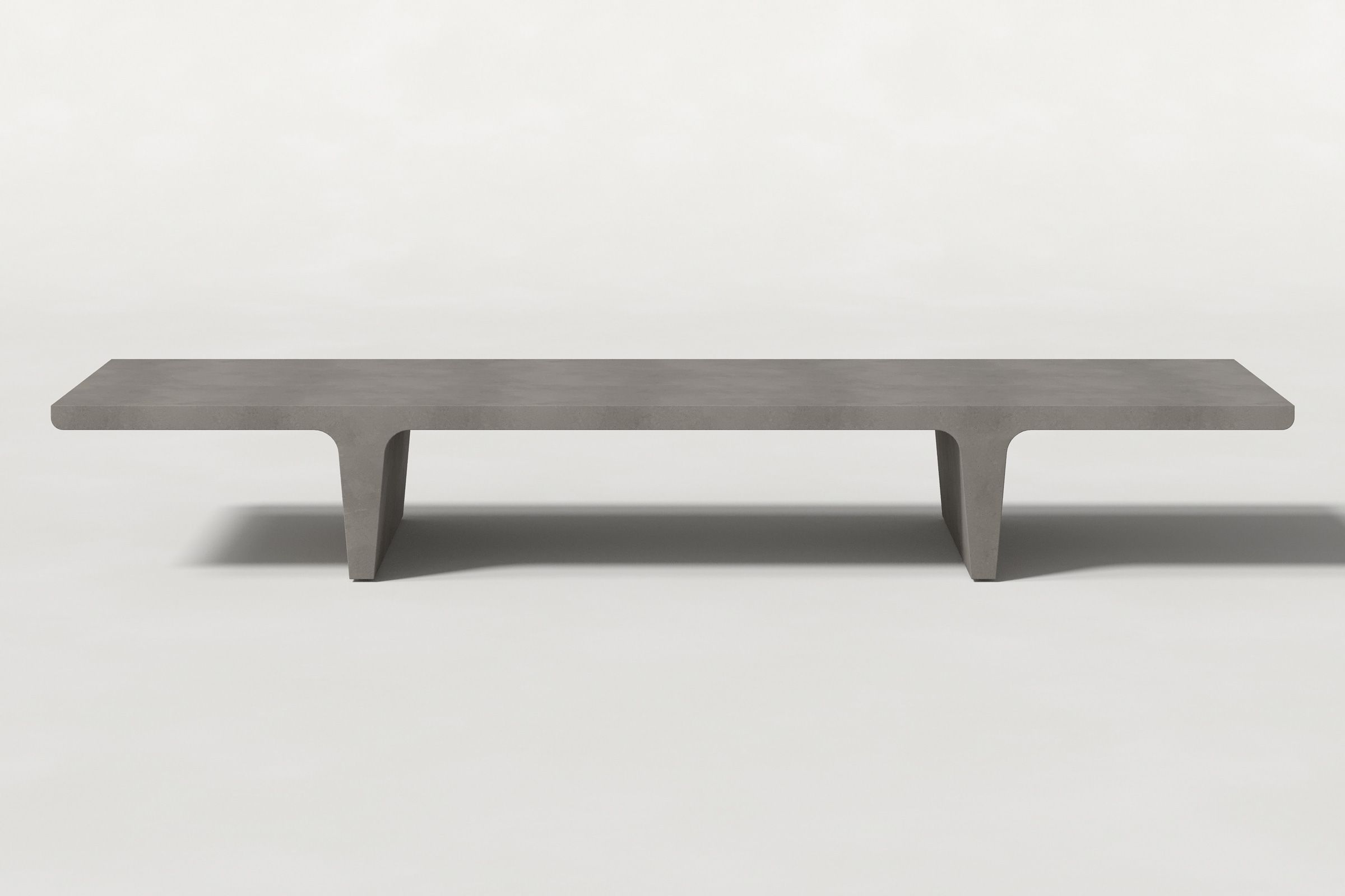 Long rectangular solid dark grey concrete coffee table with sculptural double tee legs and a smooth top, set against a clean white background.