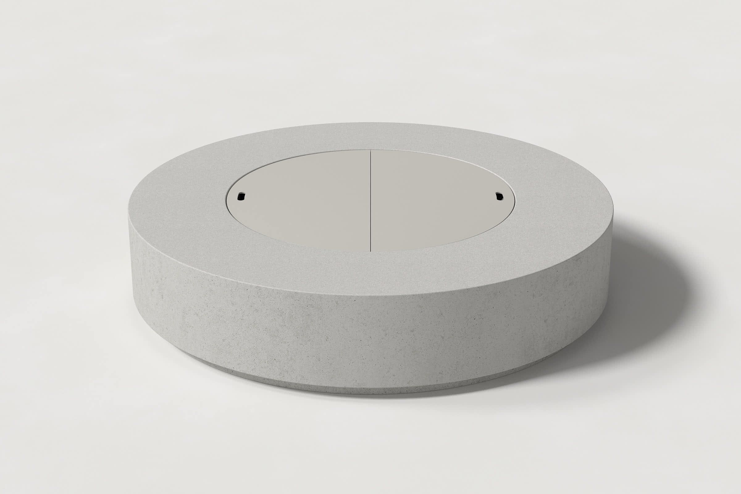 Low cylindrical soft grey concrete fire pit with thick walls and a central circular well. Mid-range angle shows the well covered with matching cover with handles against a white background.