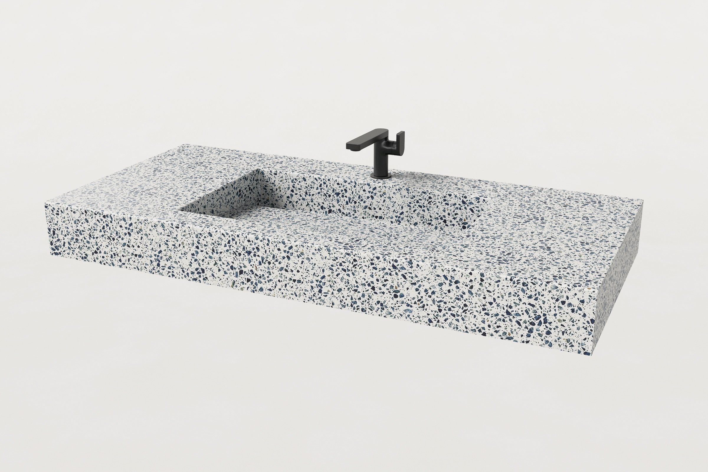 Angled top view of a terrazzo sink in Unazzo finish with rectangular basin and black faucet installed.