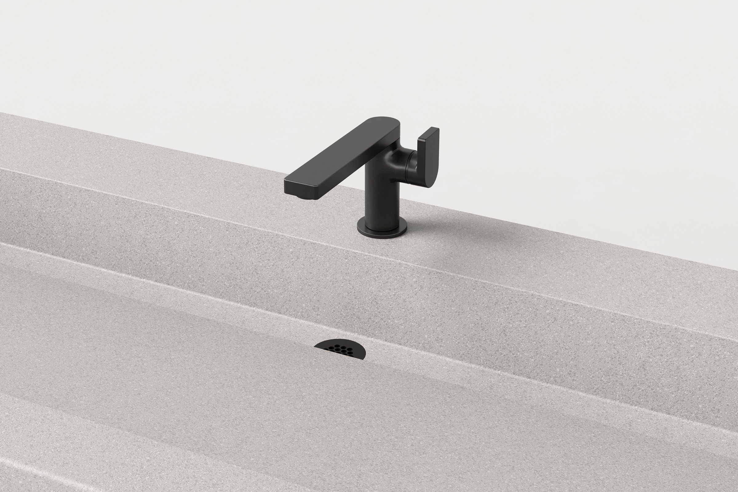 Close-up of the matte black faucet mounted on the Fog sink, with the triangular slope of the basin and the drain detail visible.