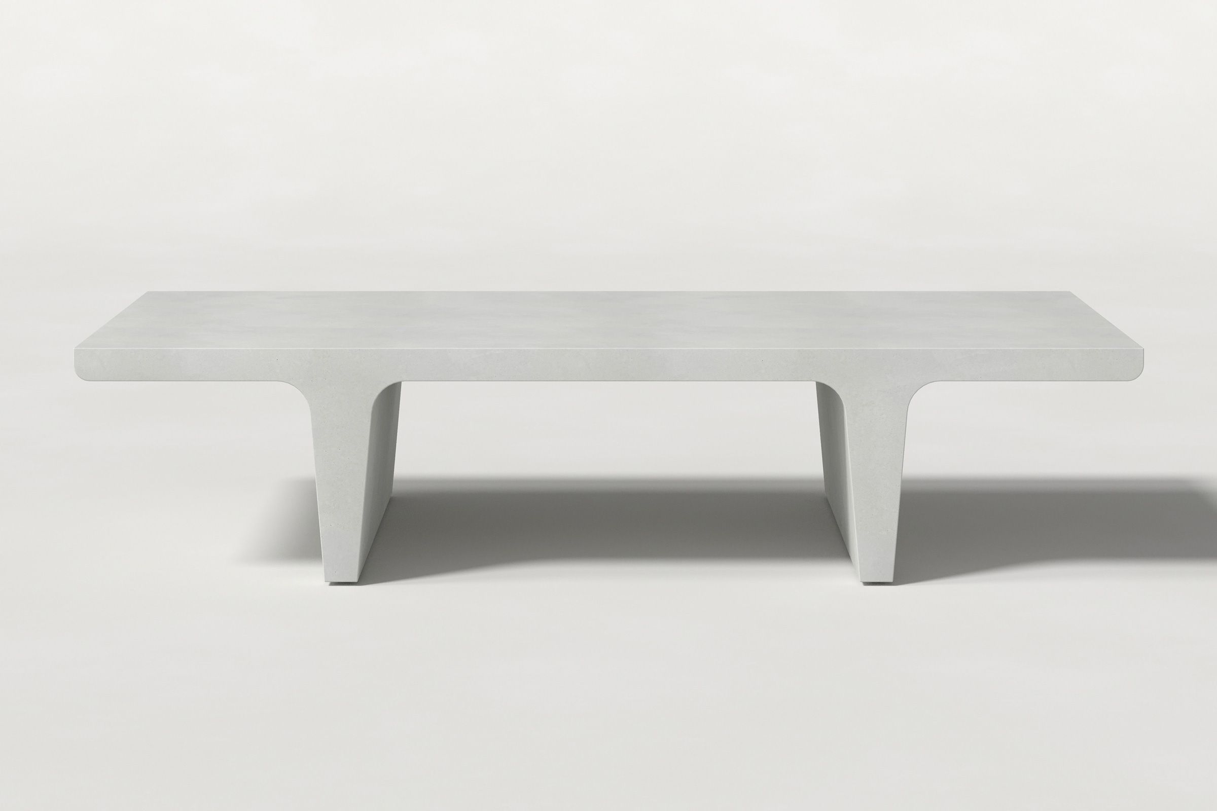 Rectangular solid white concrete coffee table with sculptural double tee legs and a smooth top, set against a clean white background.