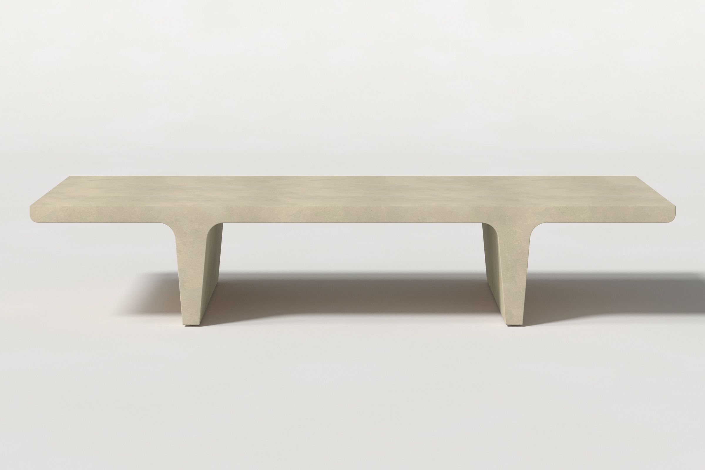 Rectangular solid light beige concrete coffee table with sculptural double tee legs and a smooth top, set against a clean white background.