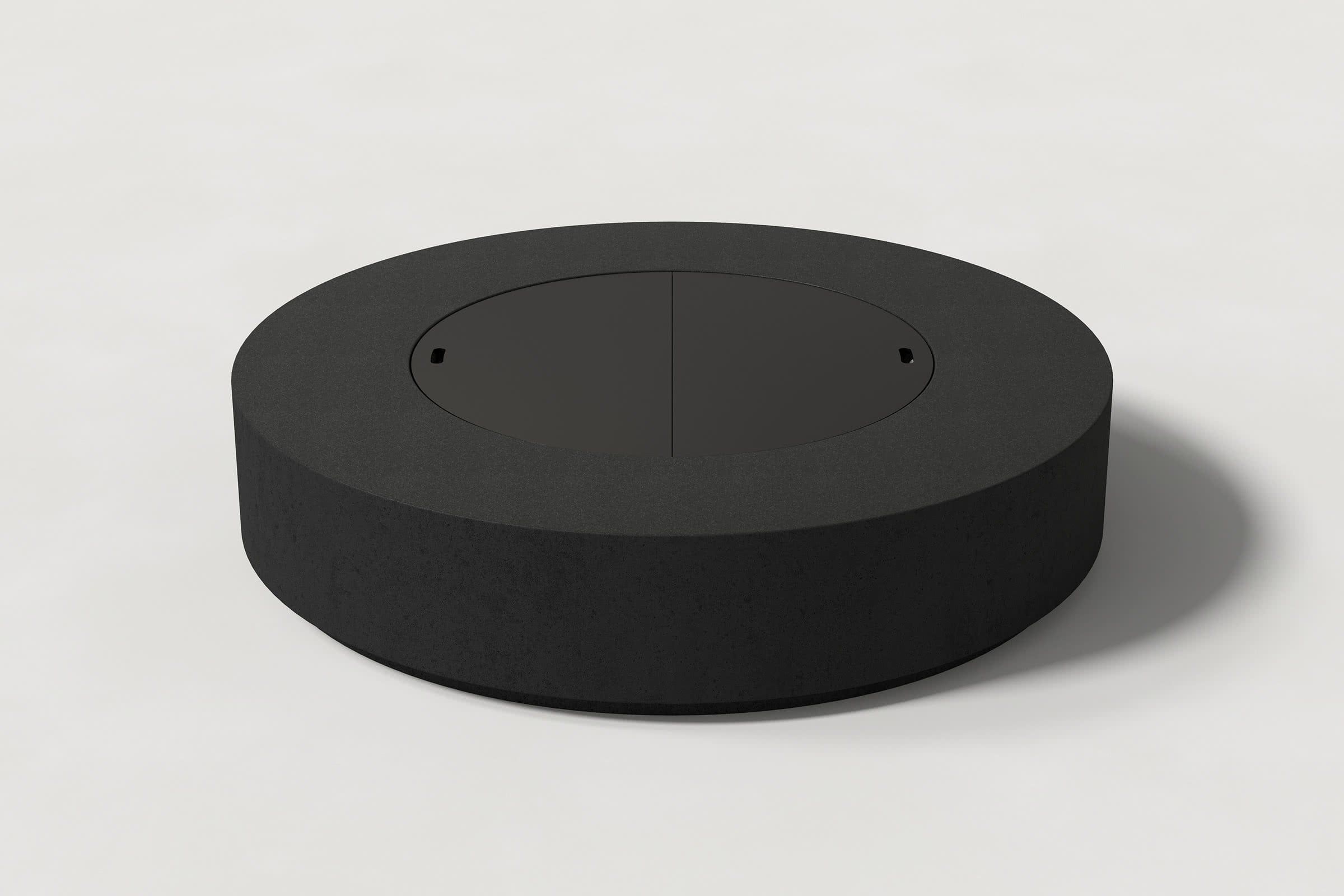 Close-up photograph of a cylindrical jet black concrete fire pit with thick walls and a well filled with volcanic rocks. Showcases a smooth texture and precise edge design.