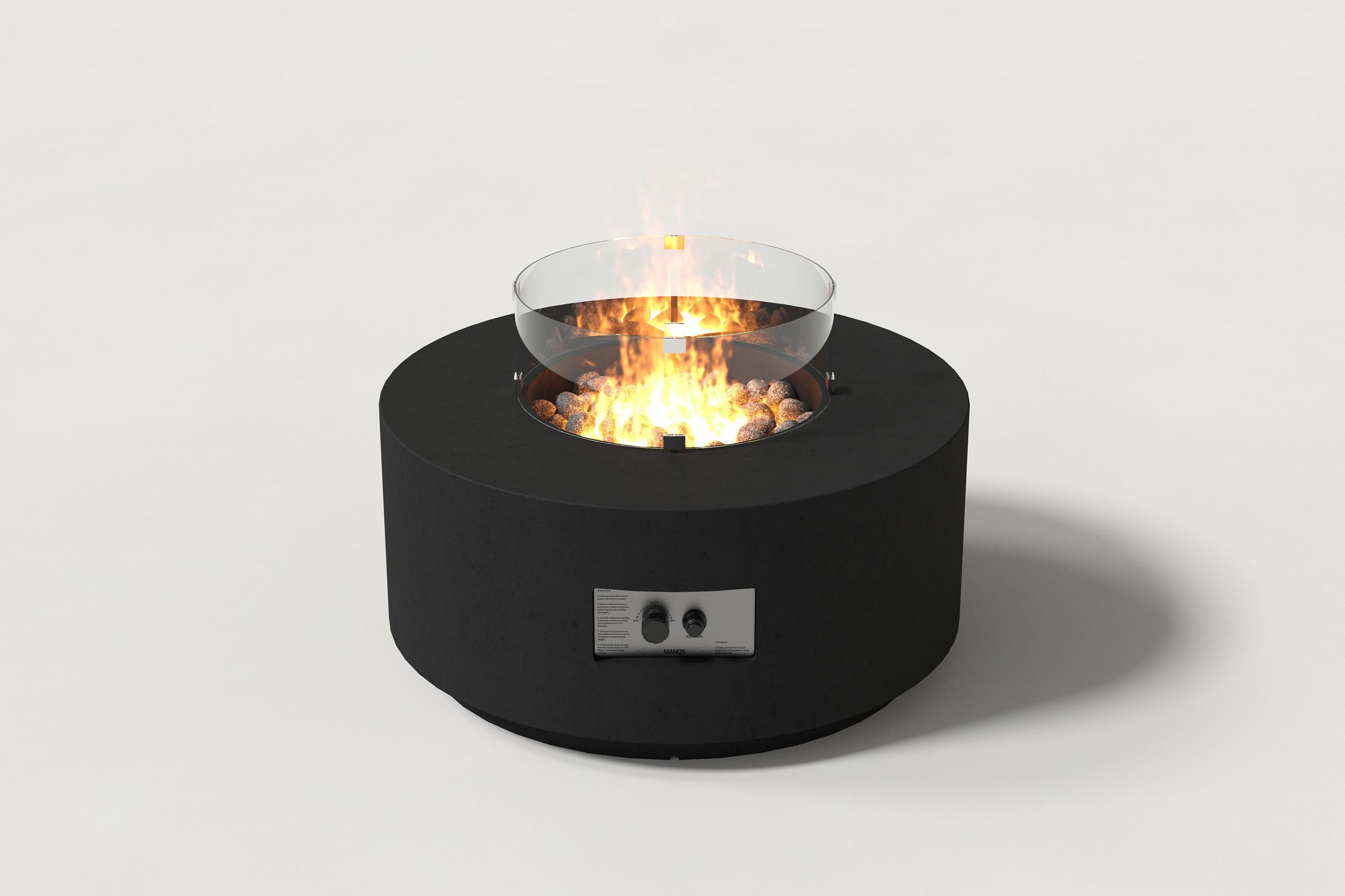 Low cylindrical black colored concrete fire pit with thick walls and a central circular well filled with dark volcanic rocks and flame, featuring an integrated control panel and glass shield. Front view on a white background.