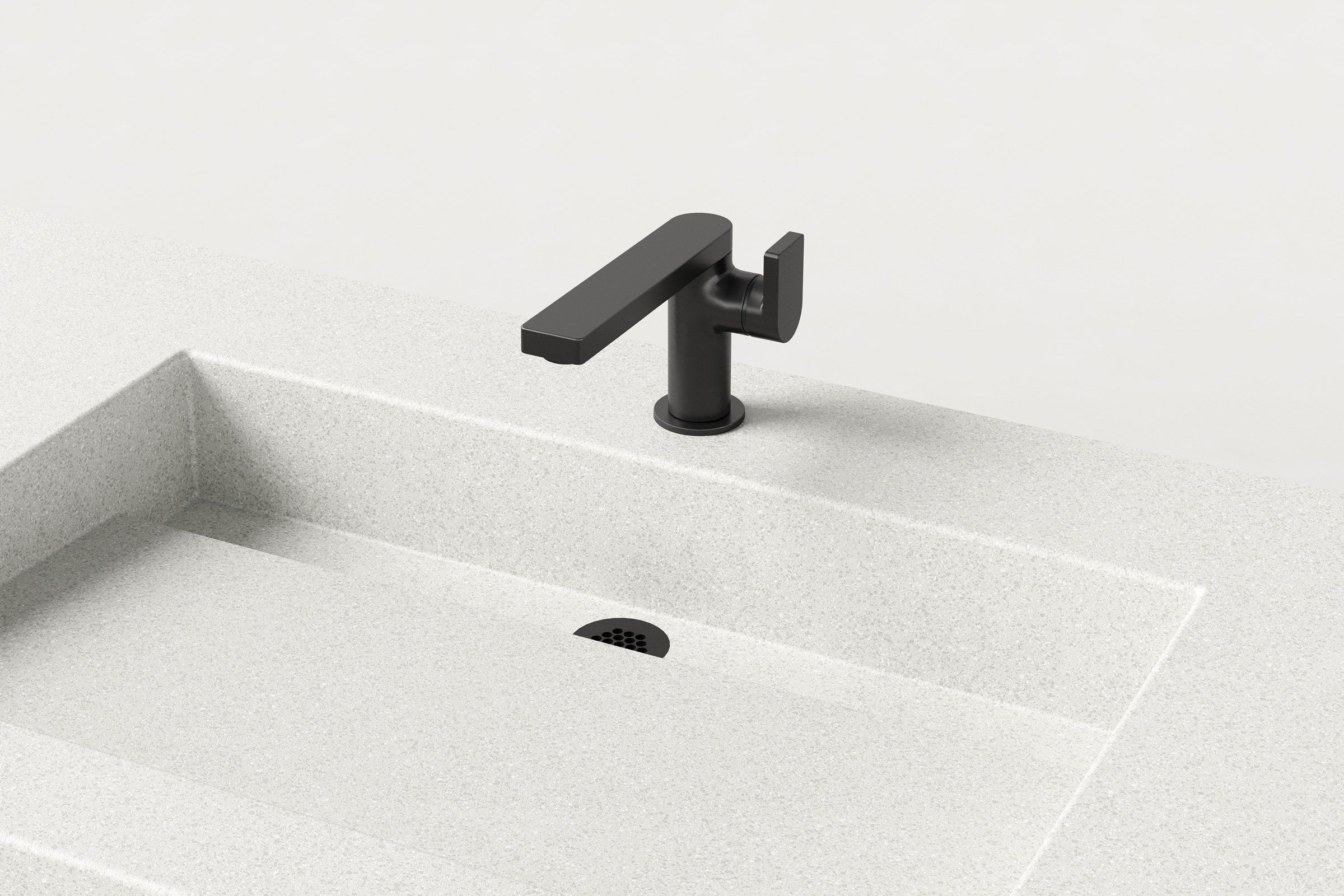 Close-up of matte black faucet mounted on Manos Trof Drop 48 concrete sink in Chalk finish with integrated drain.