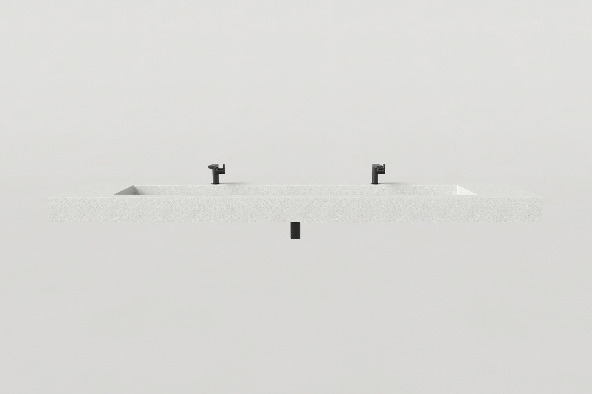 Front view of a white concrete sink with a long basin and two matte black faucets, with a centered black drain pipe beneath.