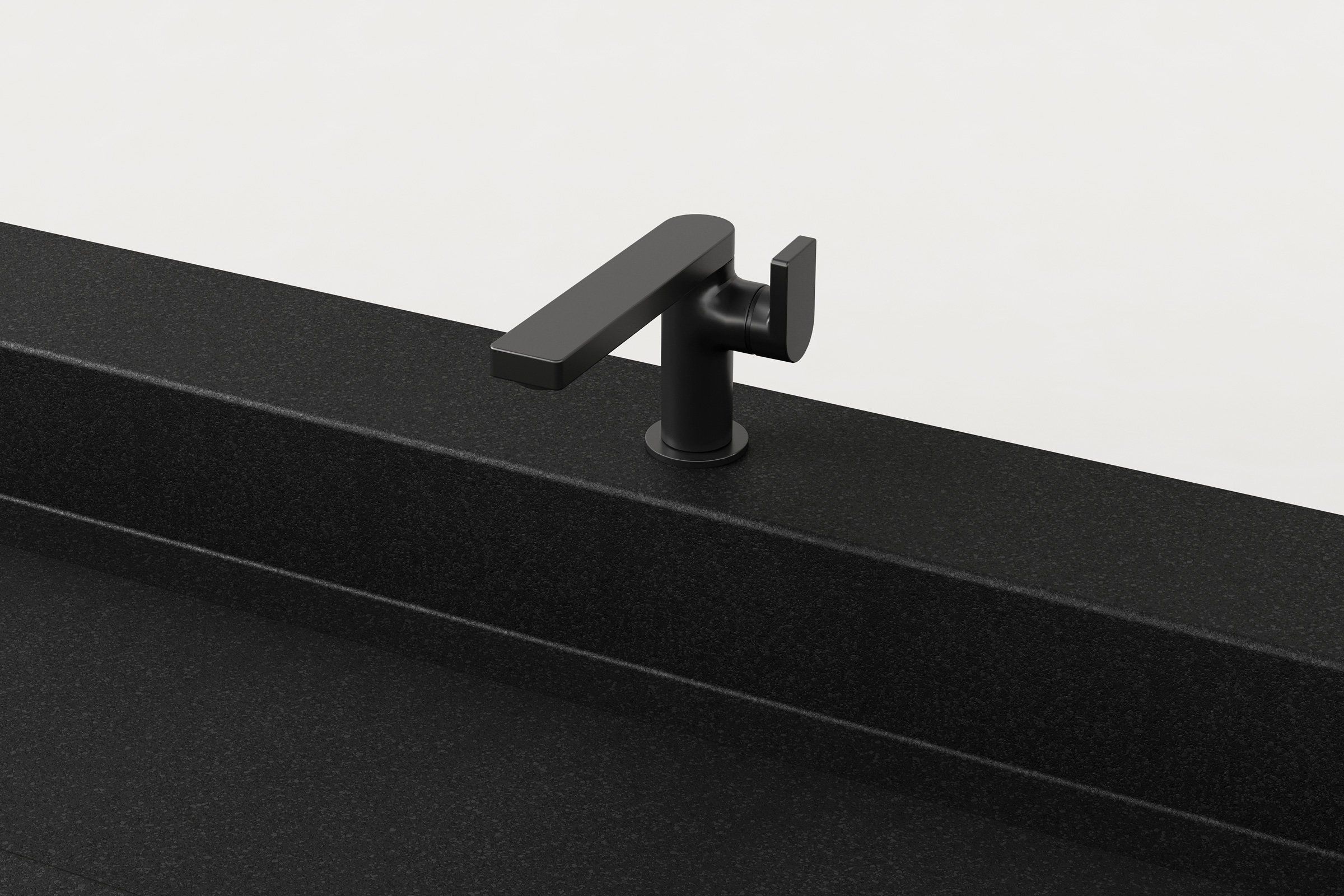 Close-up of matte black faucet mounted on a black concrete sink with integrated backsplash.