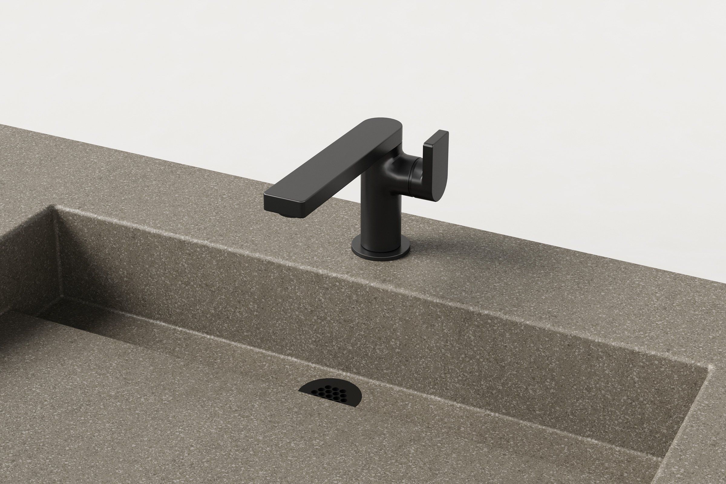 Close-up of matte black faucet and integrated drain detail on concrete double-basin sink.