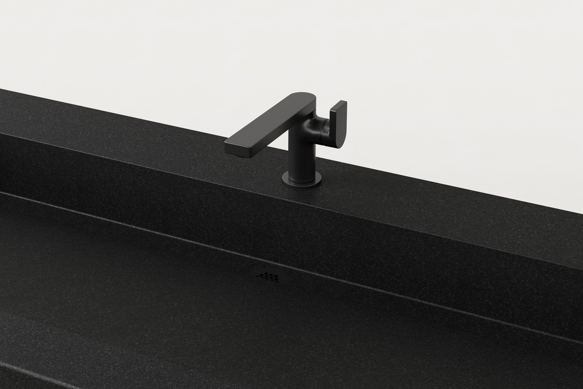Close-up of Trof sink in Storm finish showcasing matte black faucet and linear drain detail.