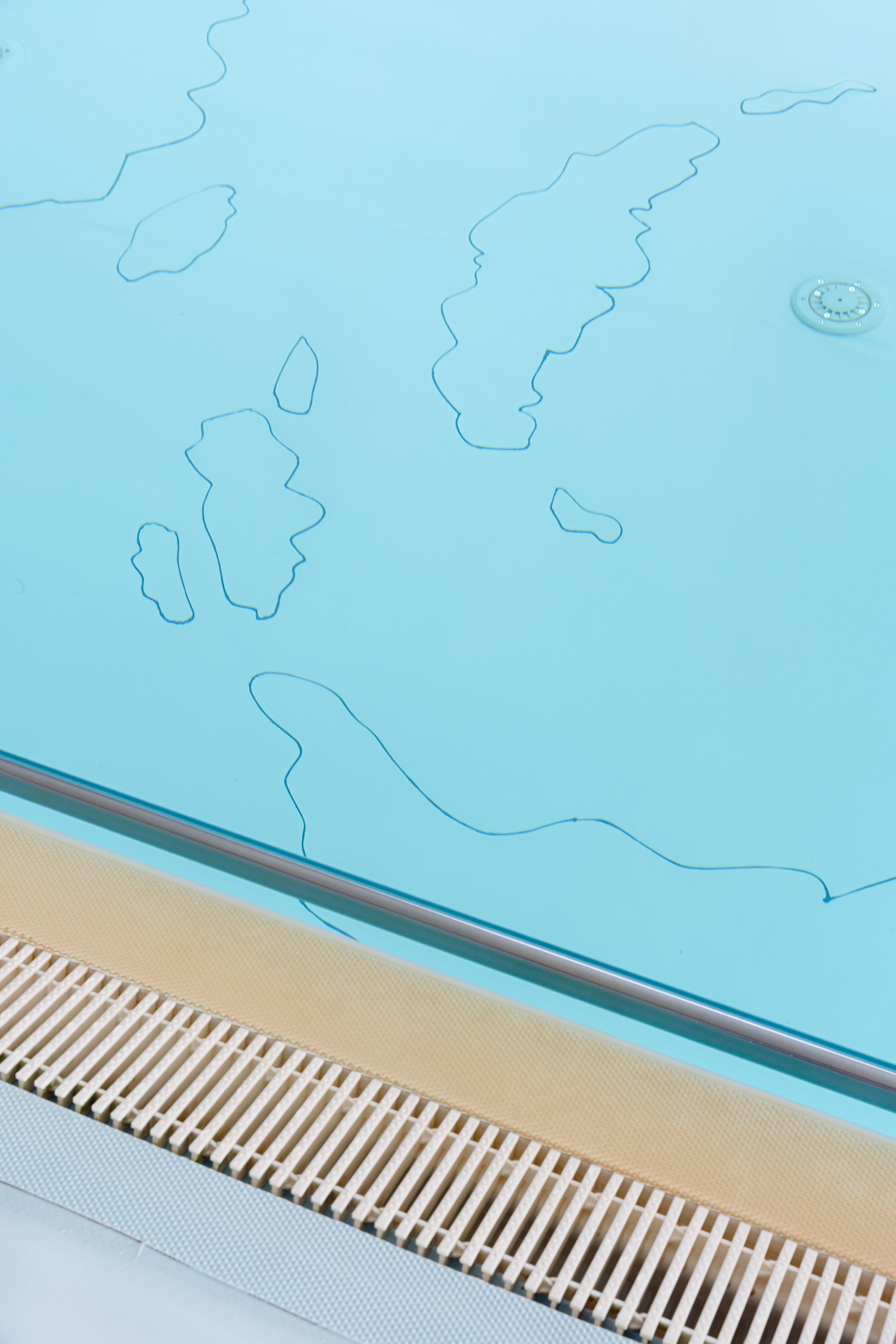 Detail of the pool floor with cloud outlines in PVC, next to the edge and drain grate