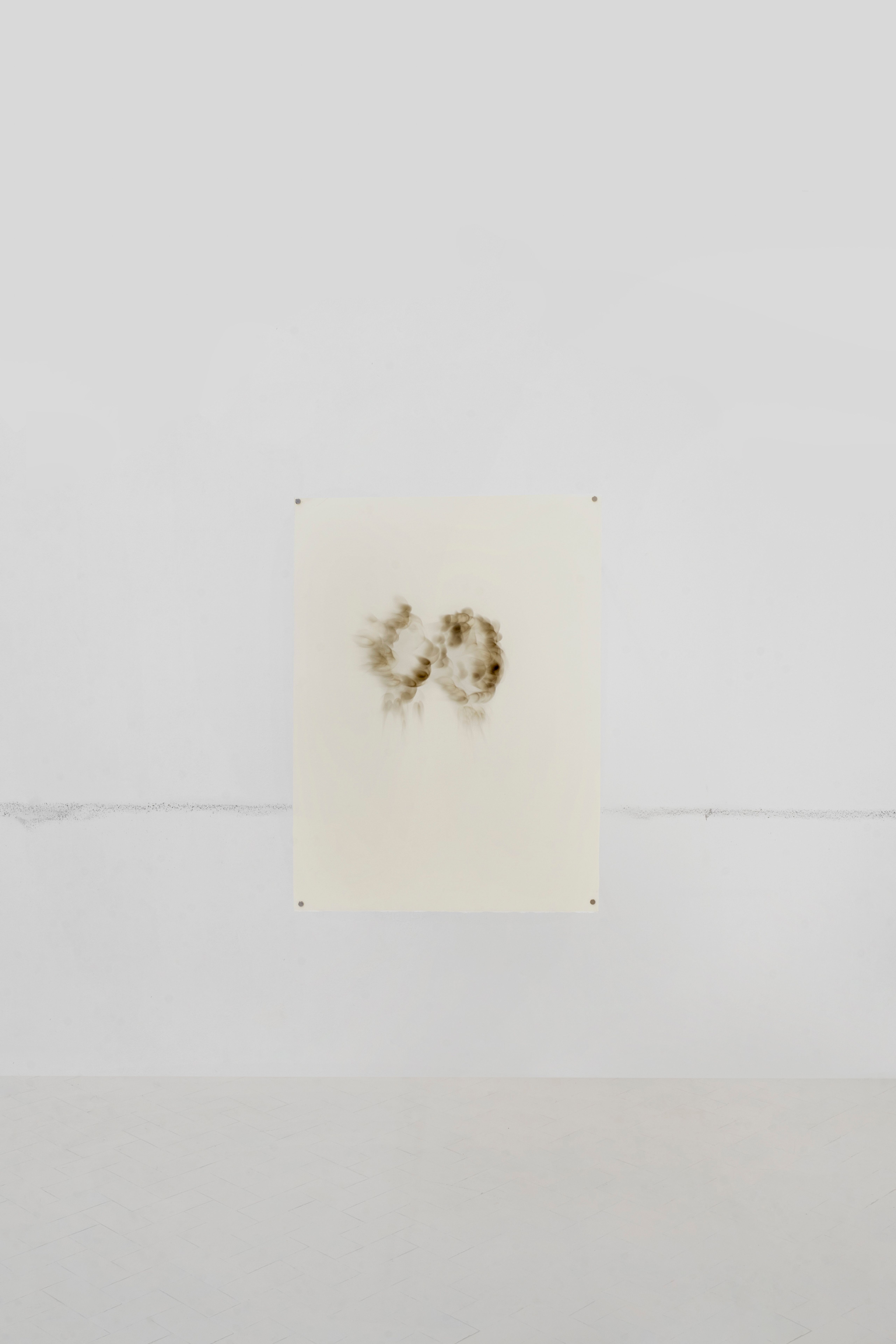 Lemon juice drawing of a pair of eyes hung on a white gallery wall