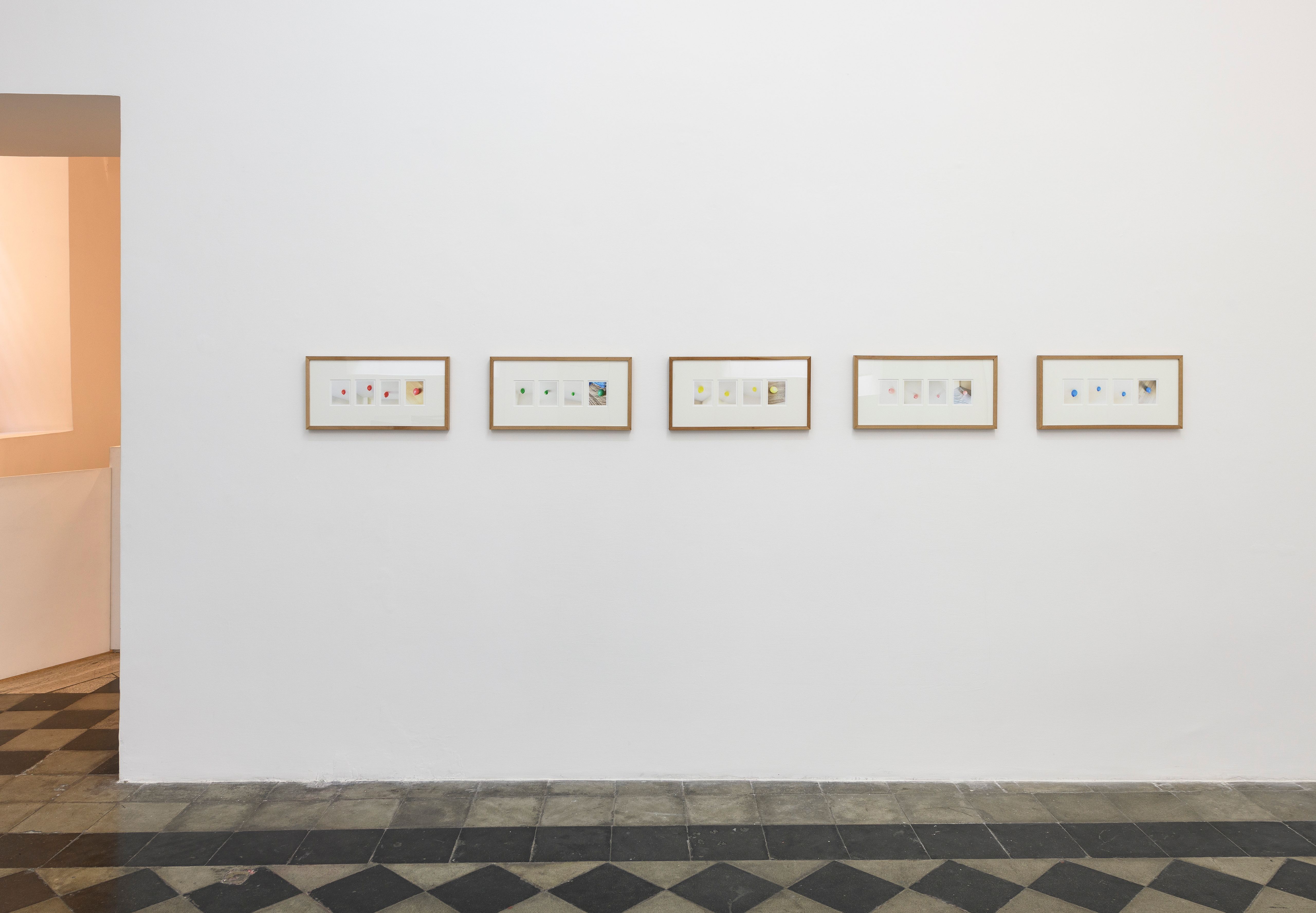 Five framed photo sequences hung in a row on a gallery wall