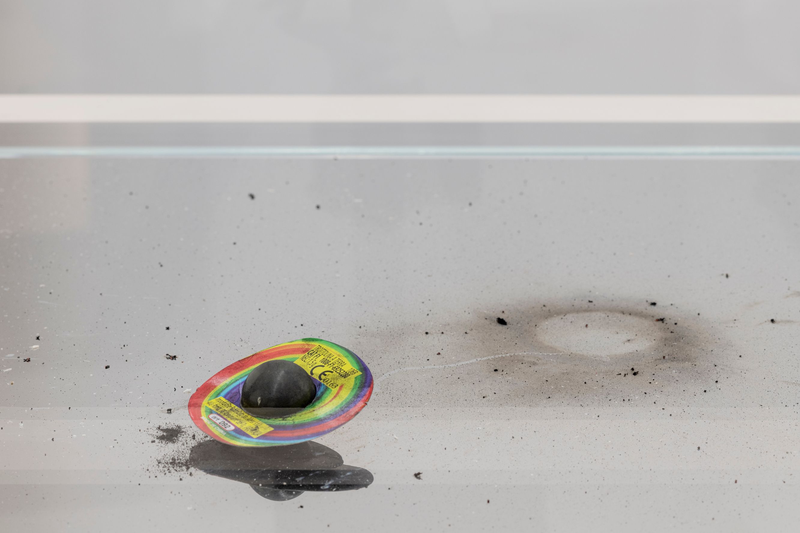 Close-up of a burnt firecracker and soot marks inside a glass case