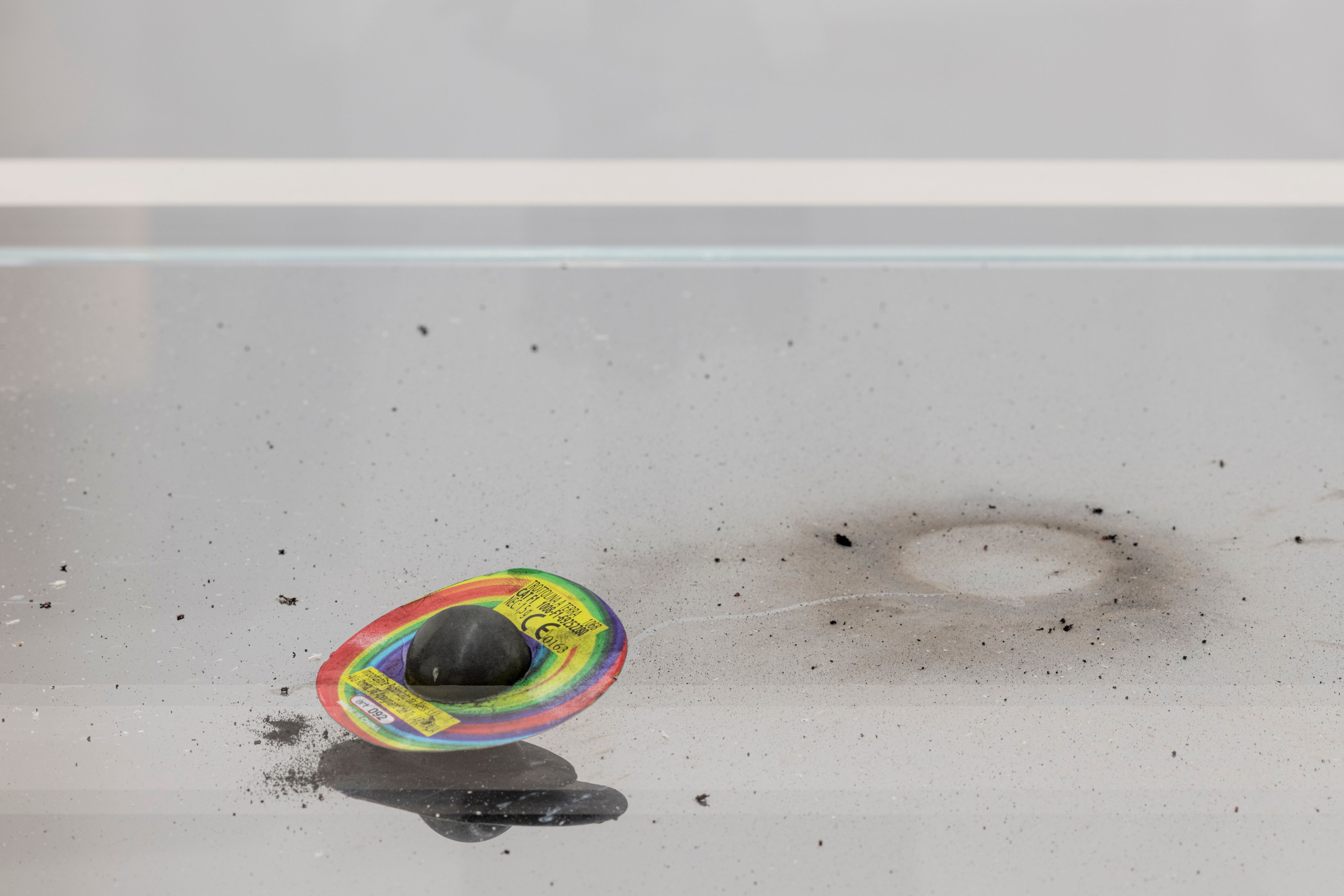 Close-up of a burnt firecracker and soot marks inside a glass case