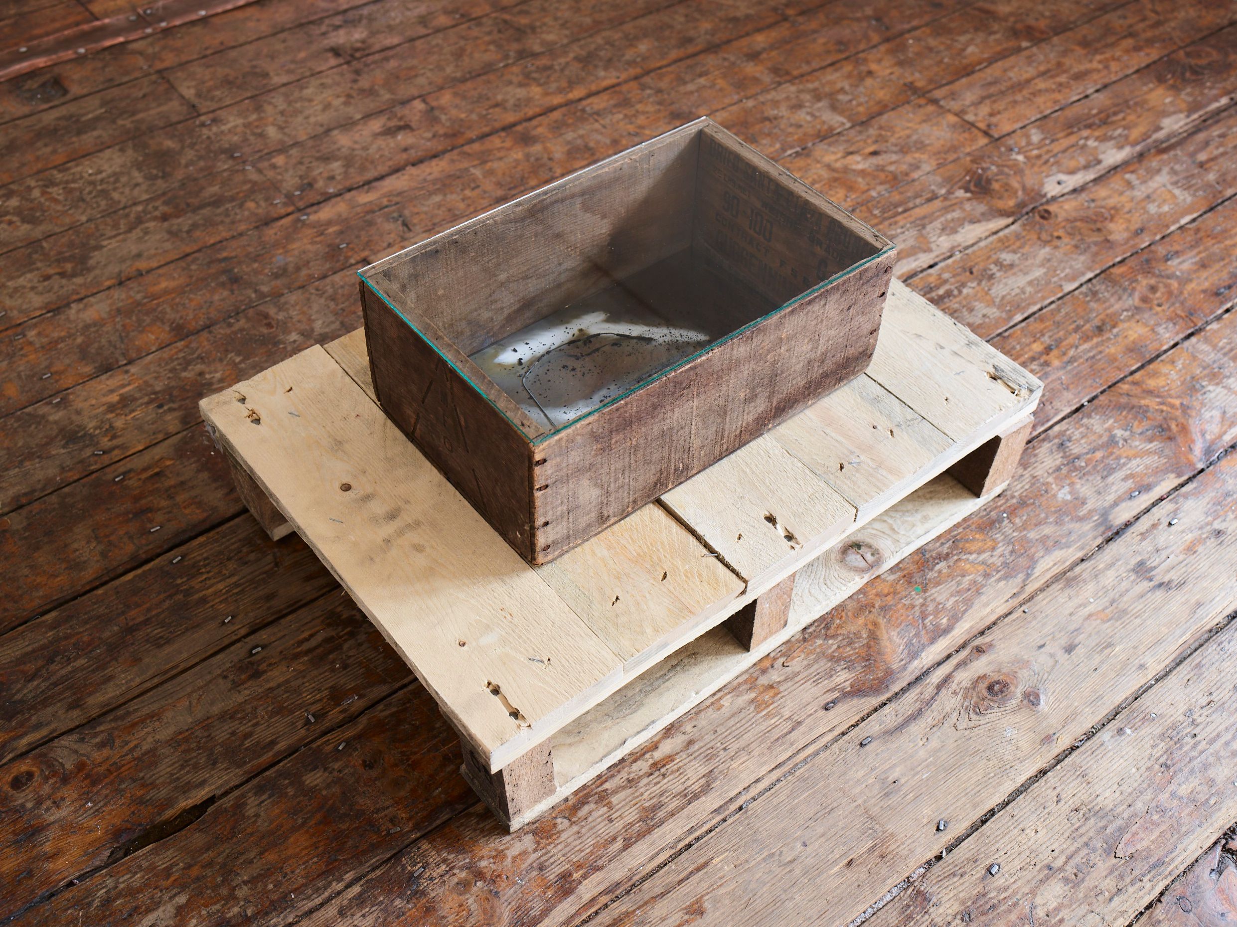 Dark wooden case on a pallet on a wooden floor