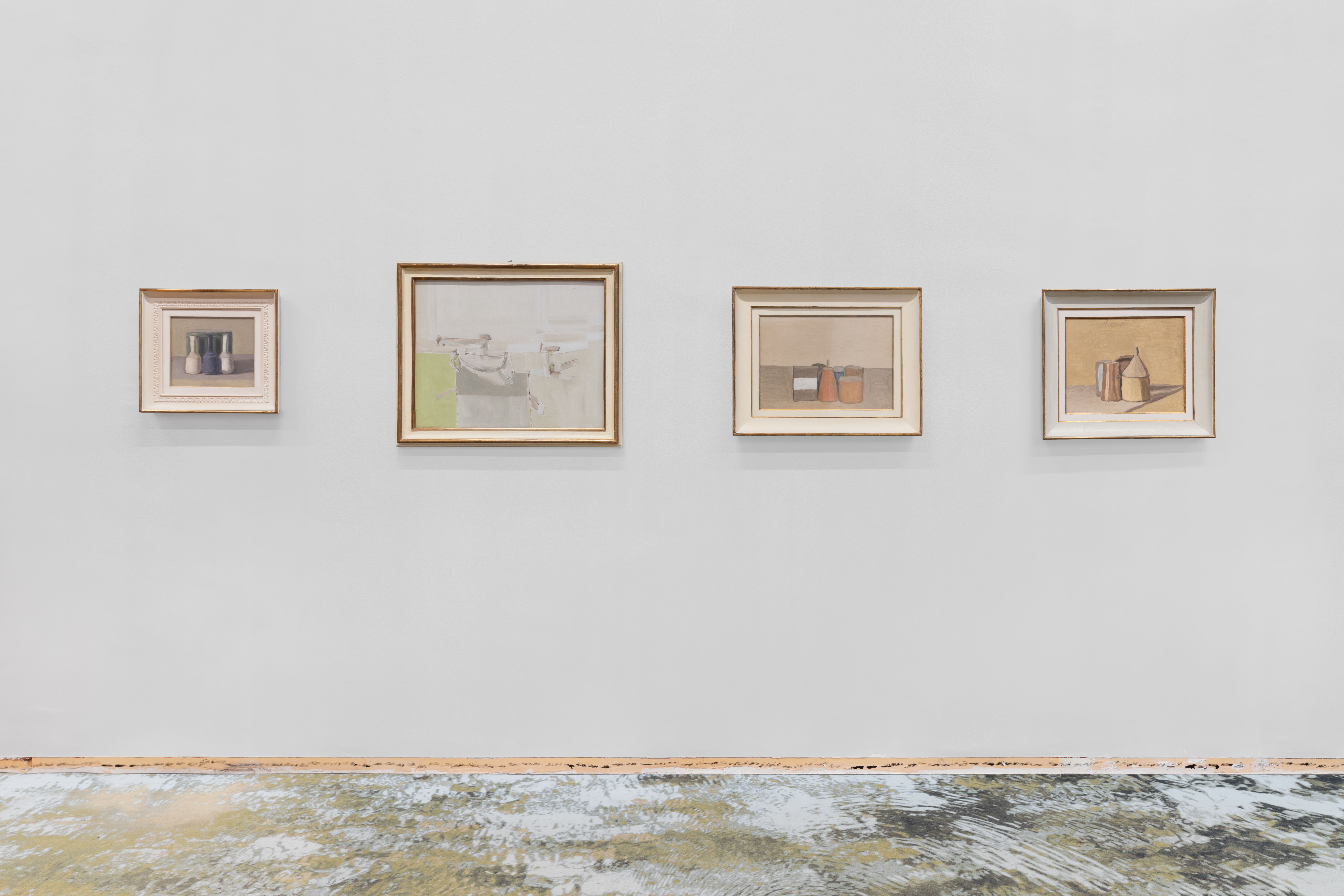 Four small framed pictures on a grey wall above a line of star prints