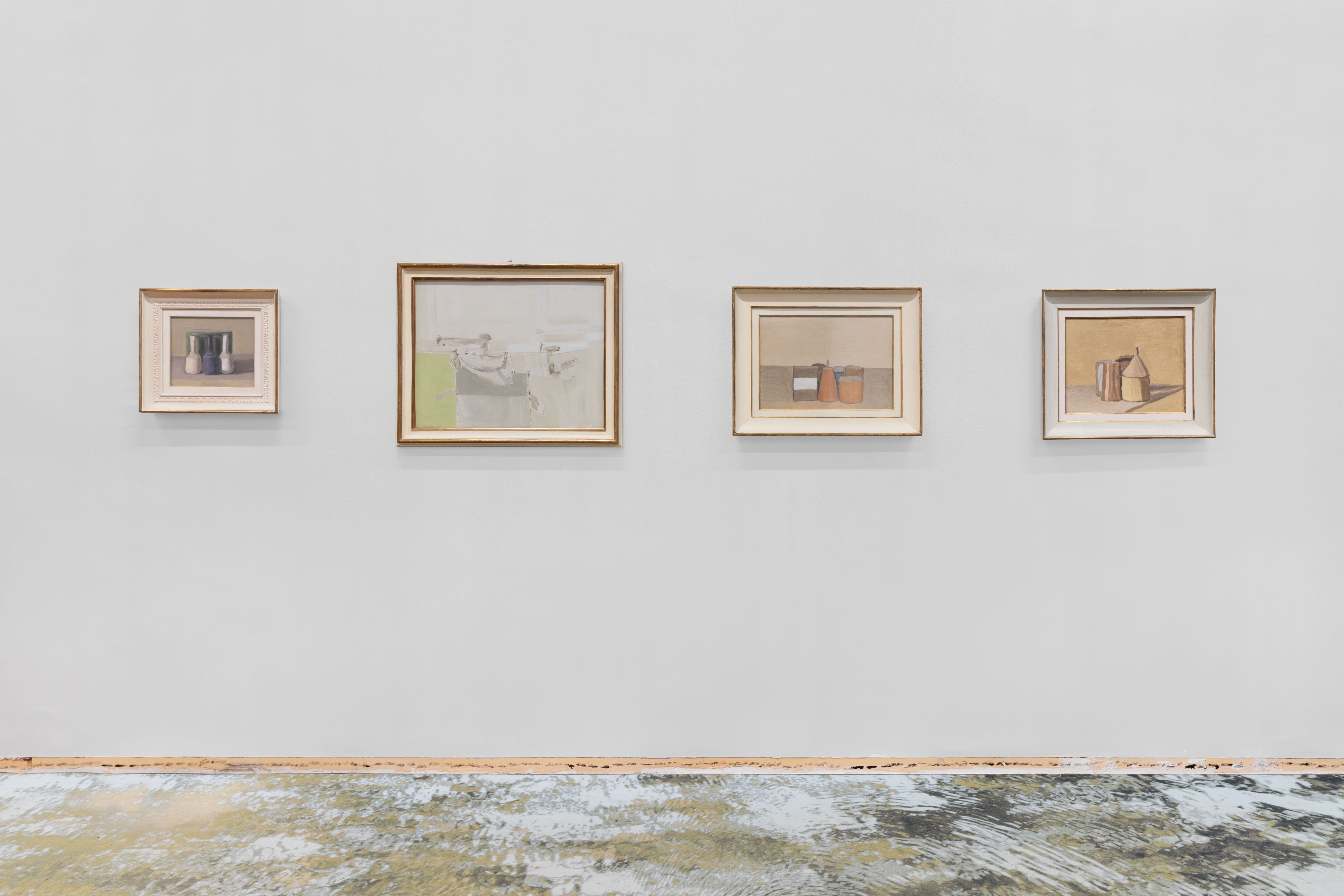 Four small framed pictures on a grey wall above a line of star prints