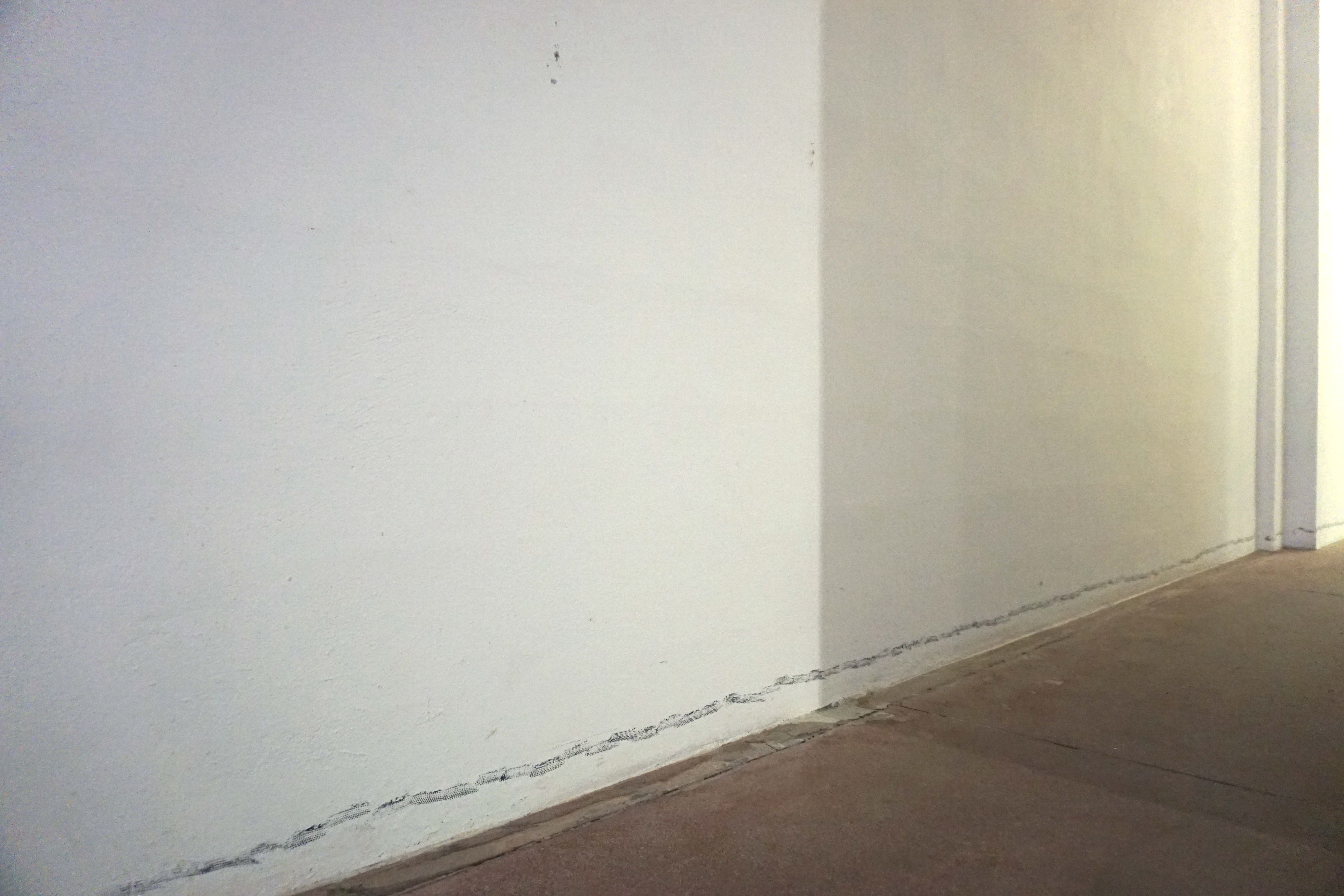 White walls with a line of dark prints along the floor