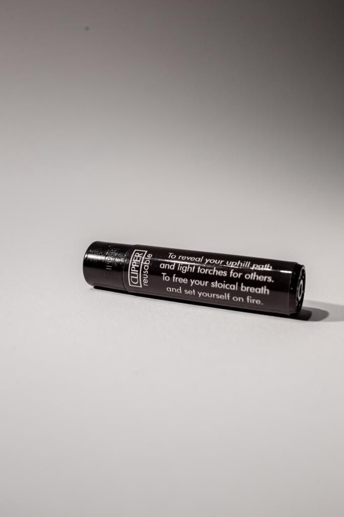 Black lighter lying on its side, printed with the poem