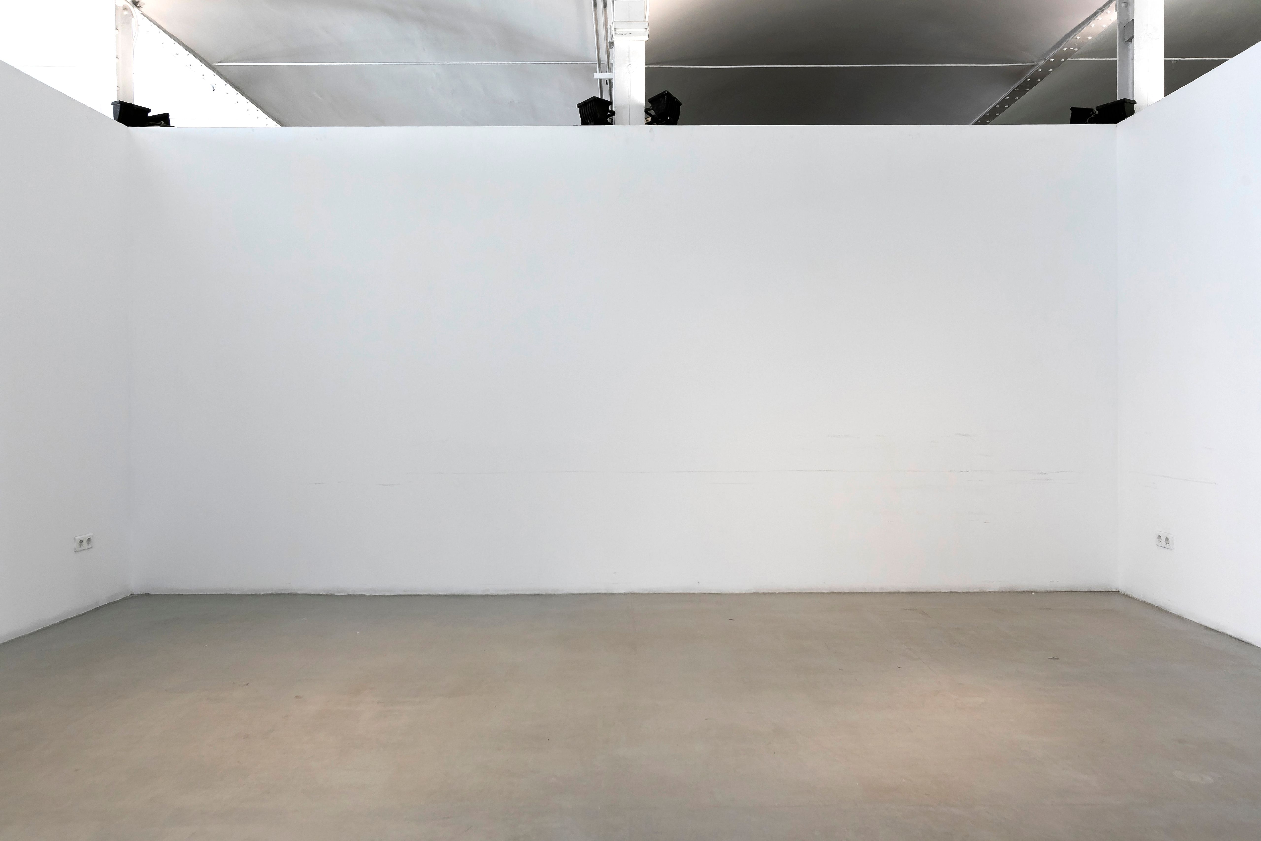 Empty white room with faint chair marks along the base of the walls
