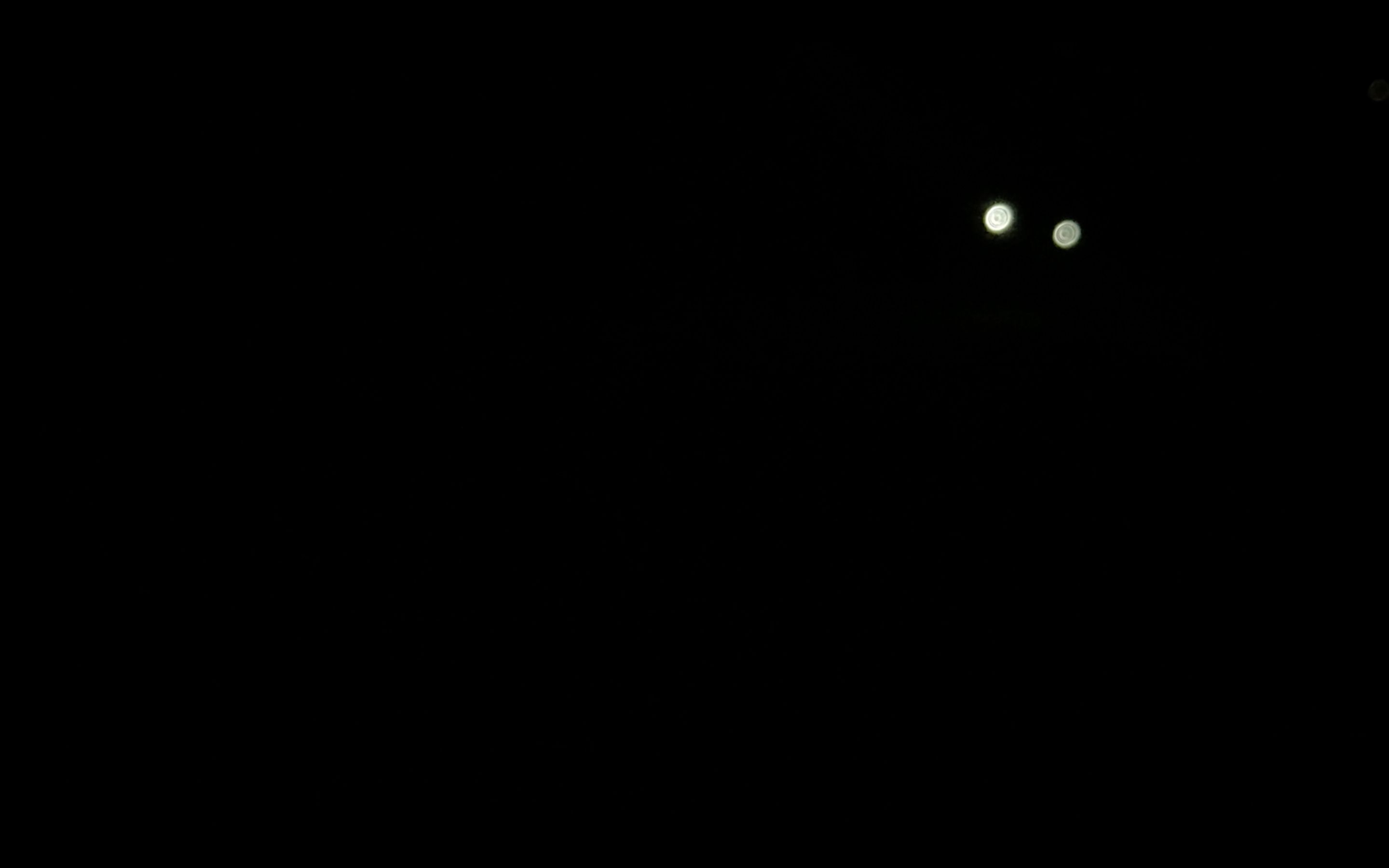 Video still: a single point of torchlight in the dark during the night game