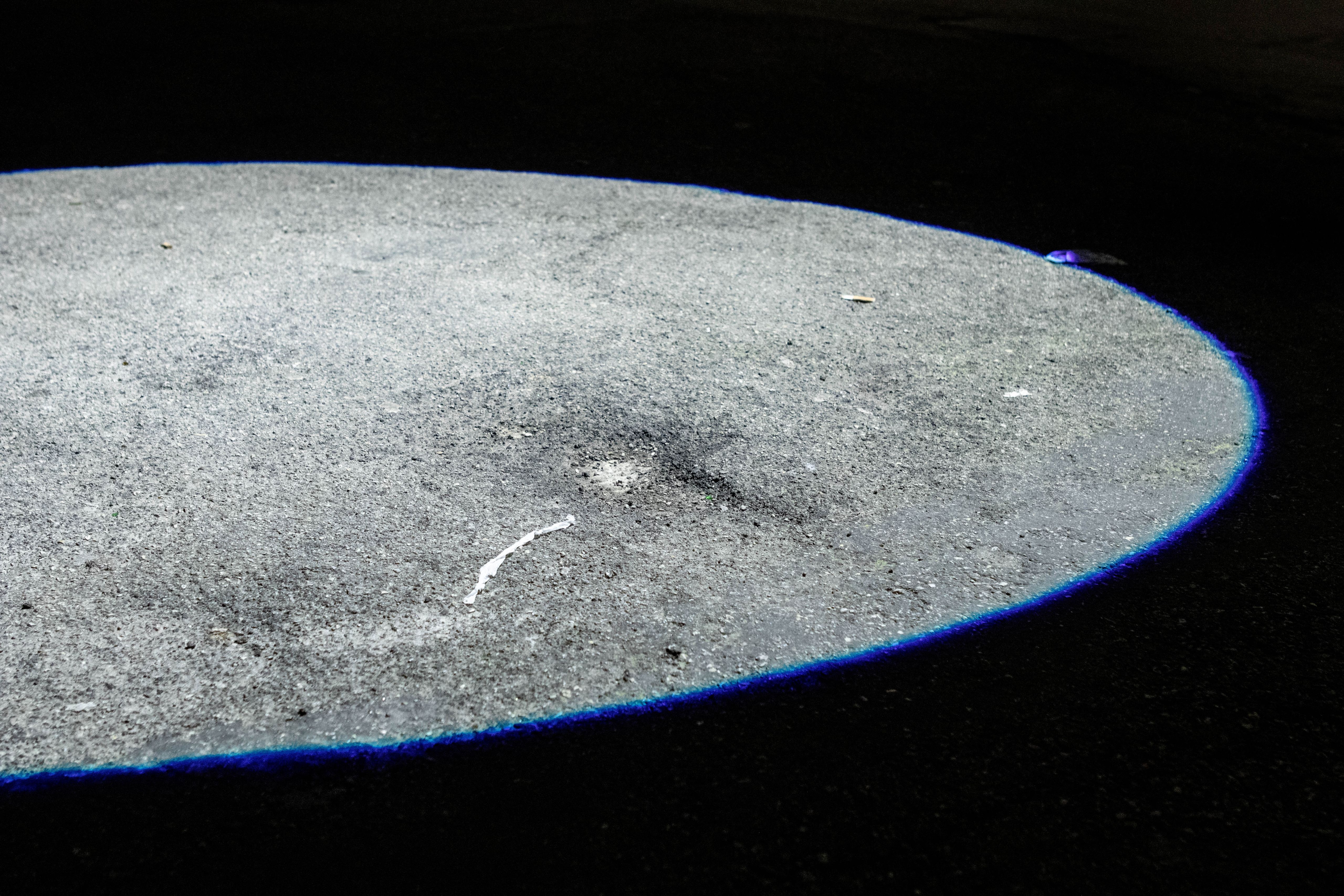 Oval spot of light projected on a dark street surface