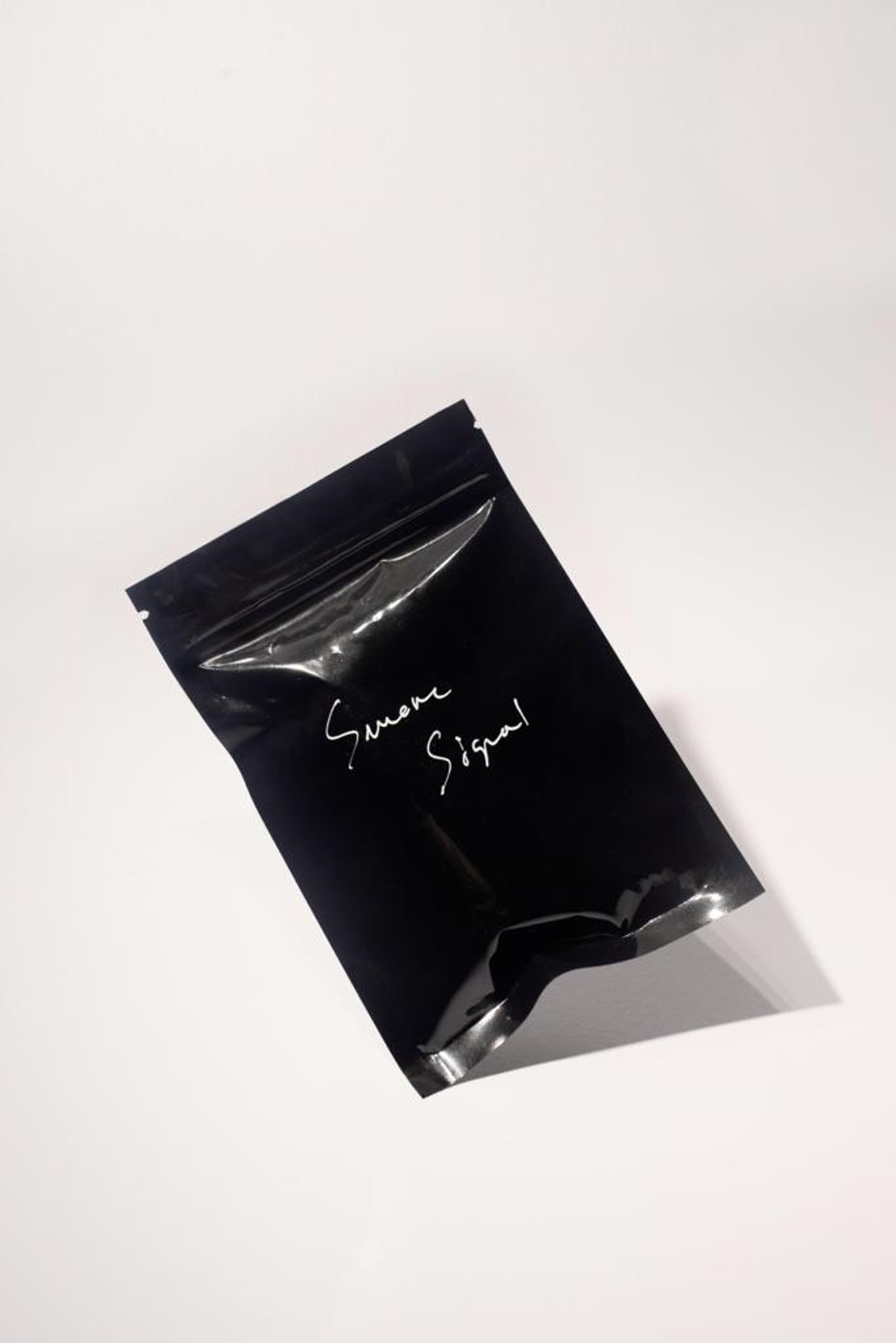 Black zip bag with Smoke Signal handwritten on it