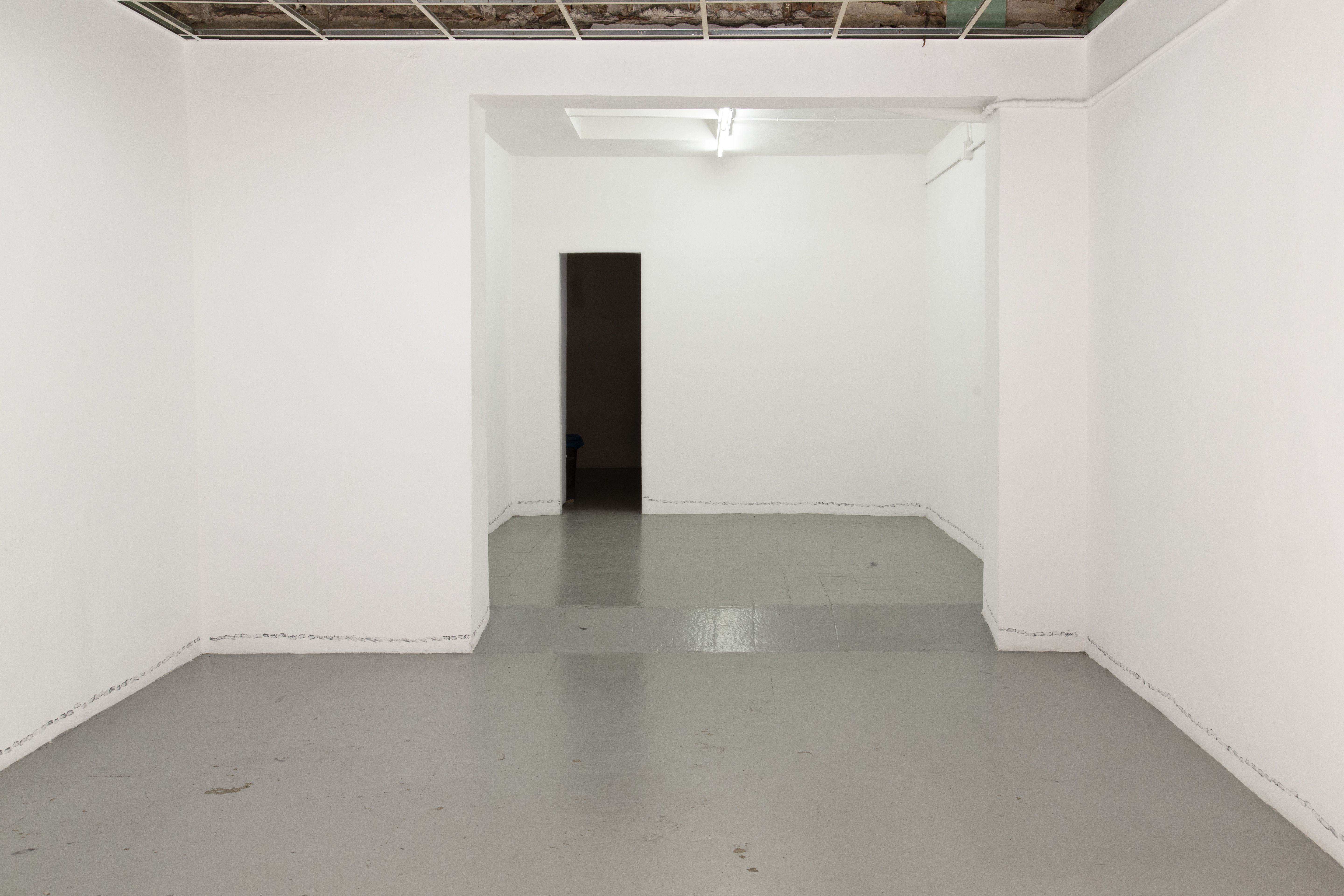 Empty white room with a grey floor and star prints along the base of the walls