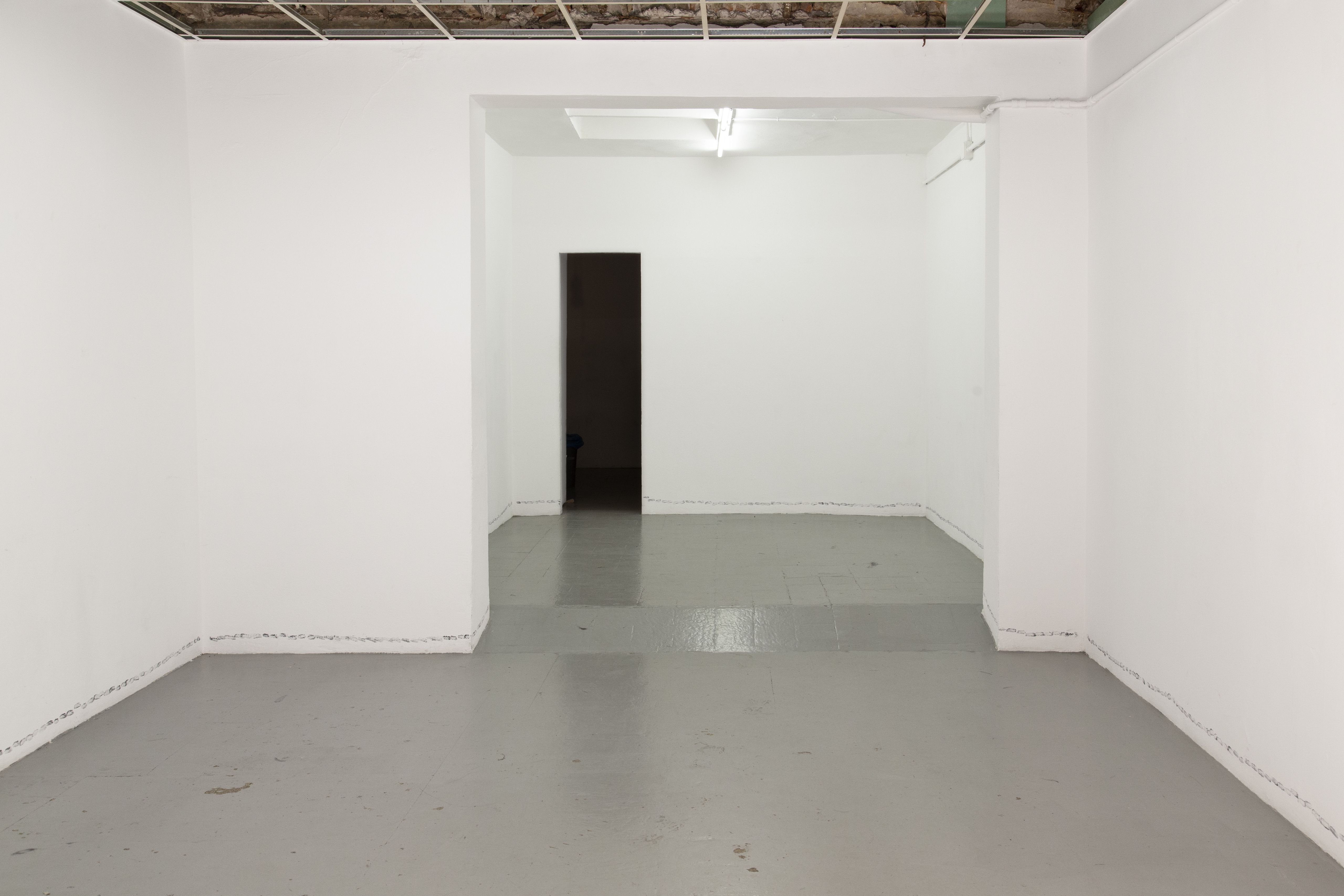 Empty white room with a grey floor and star prints along the base of the walls