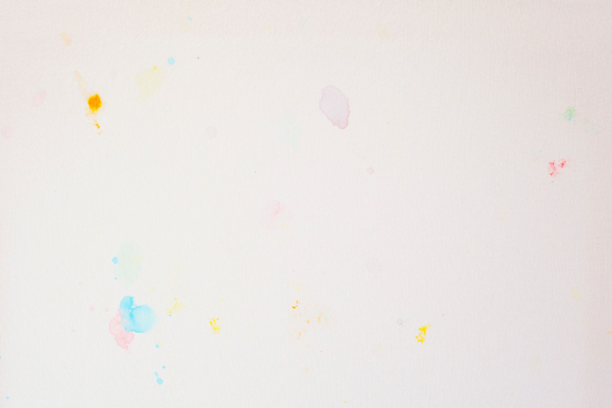 Detail of pale coloured m&m's stains on a white sheet