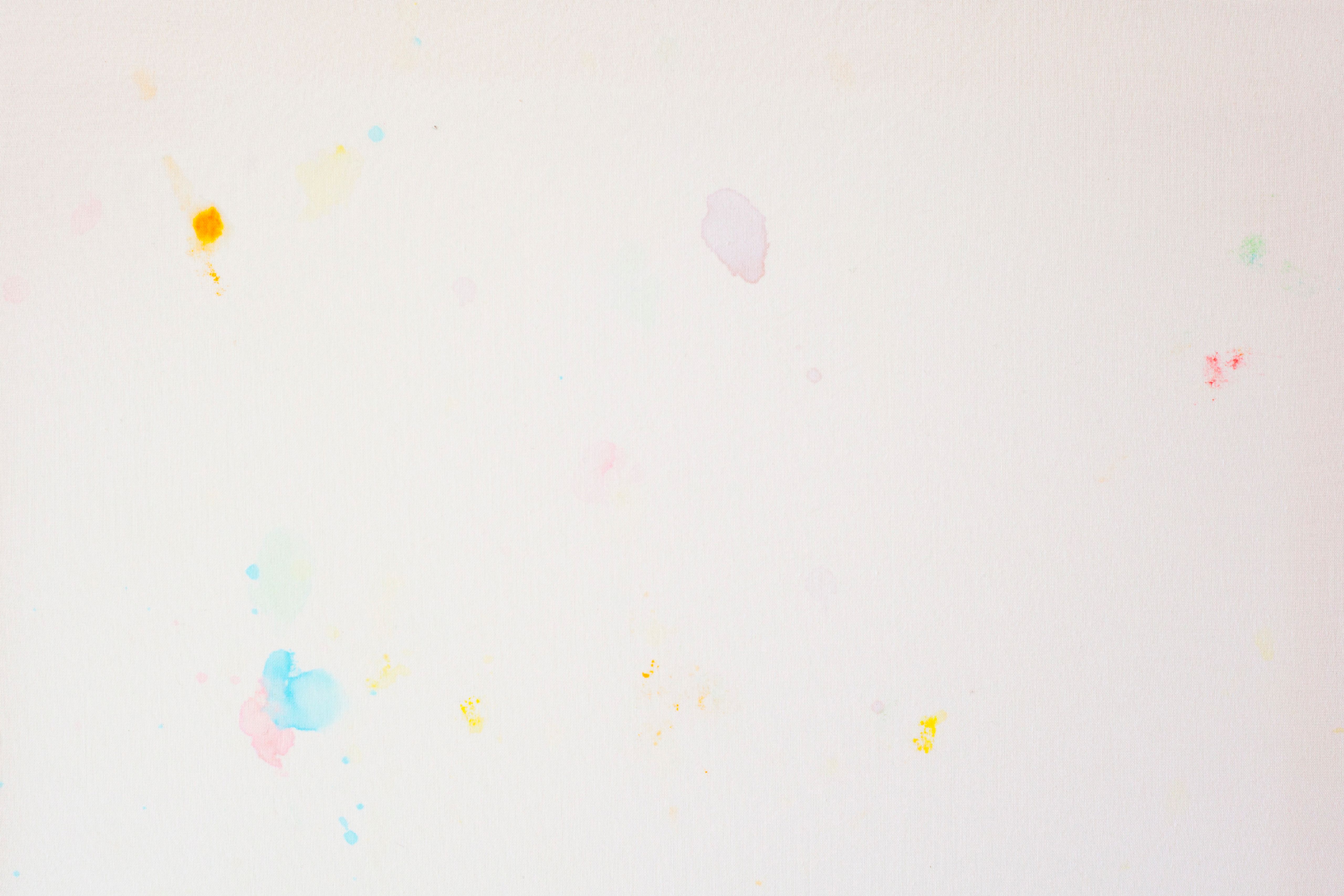 Detail of pale coloured m&m's stains on a white sheet