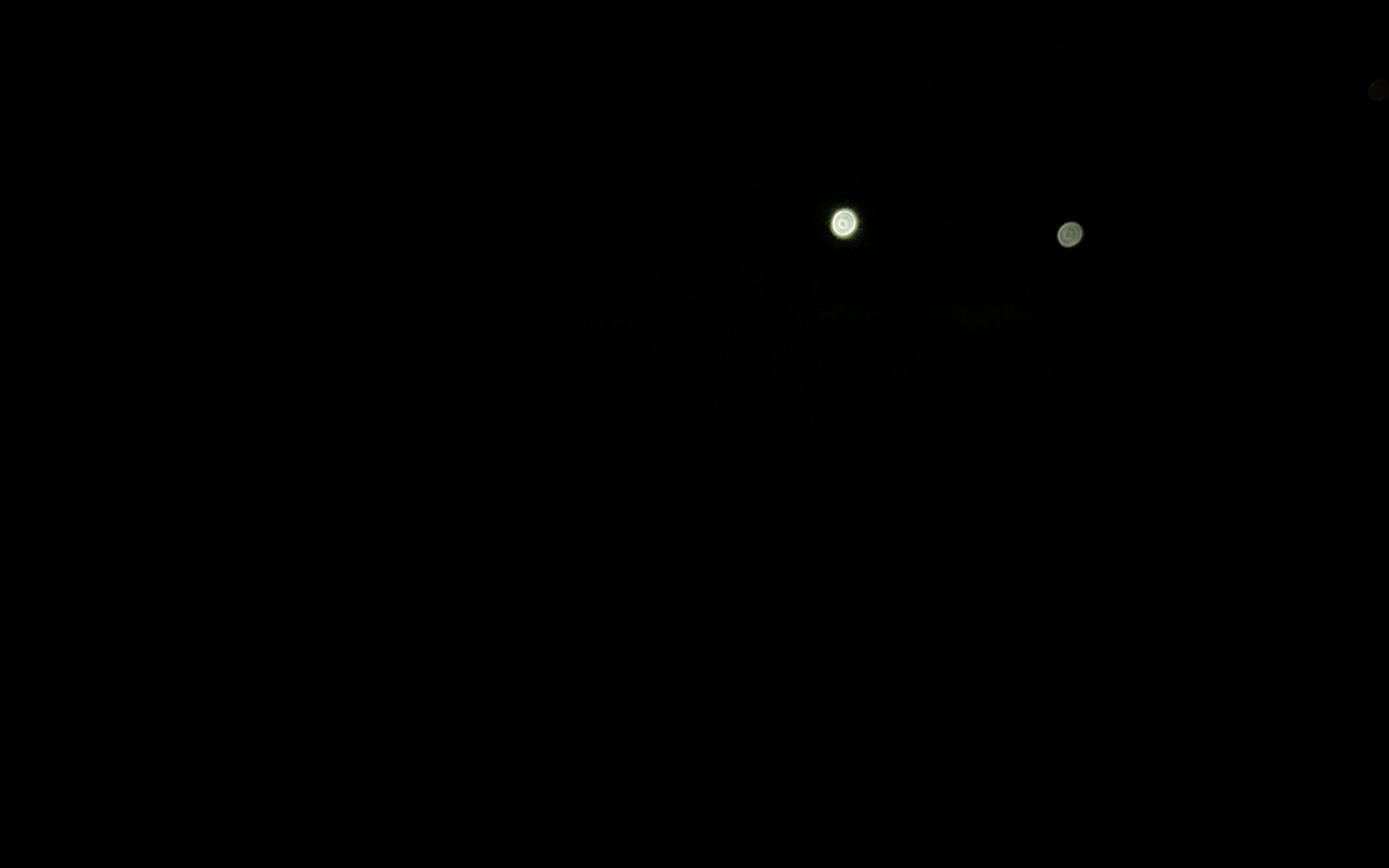 Video still: two torchlights in the dark during the night game