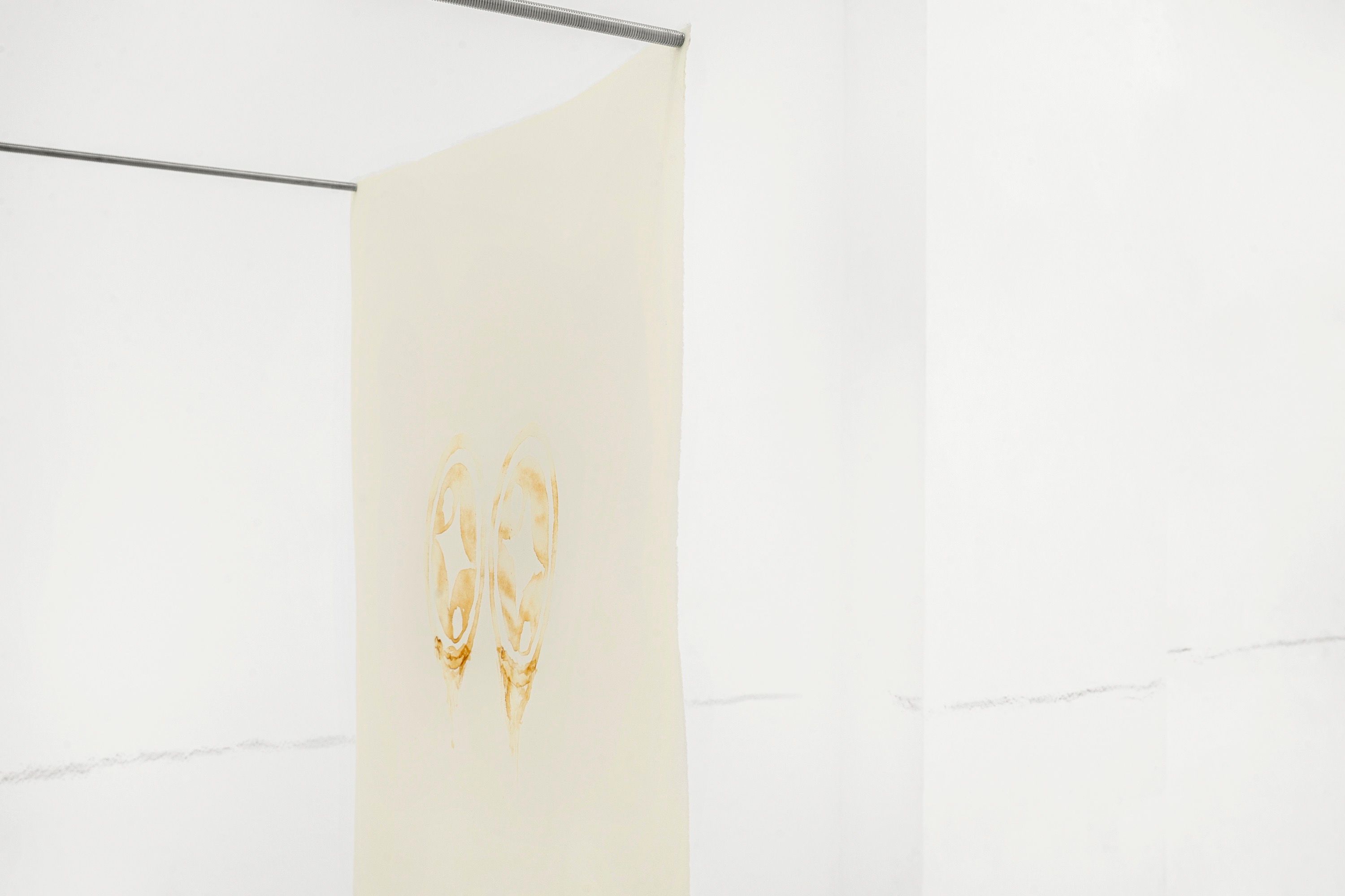 Drawing on paper held by thin iron rods projecting from a gallery corner