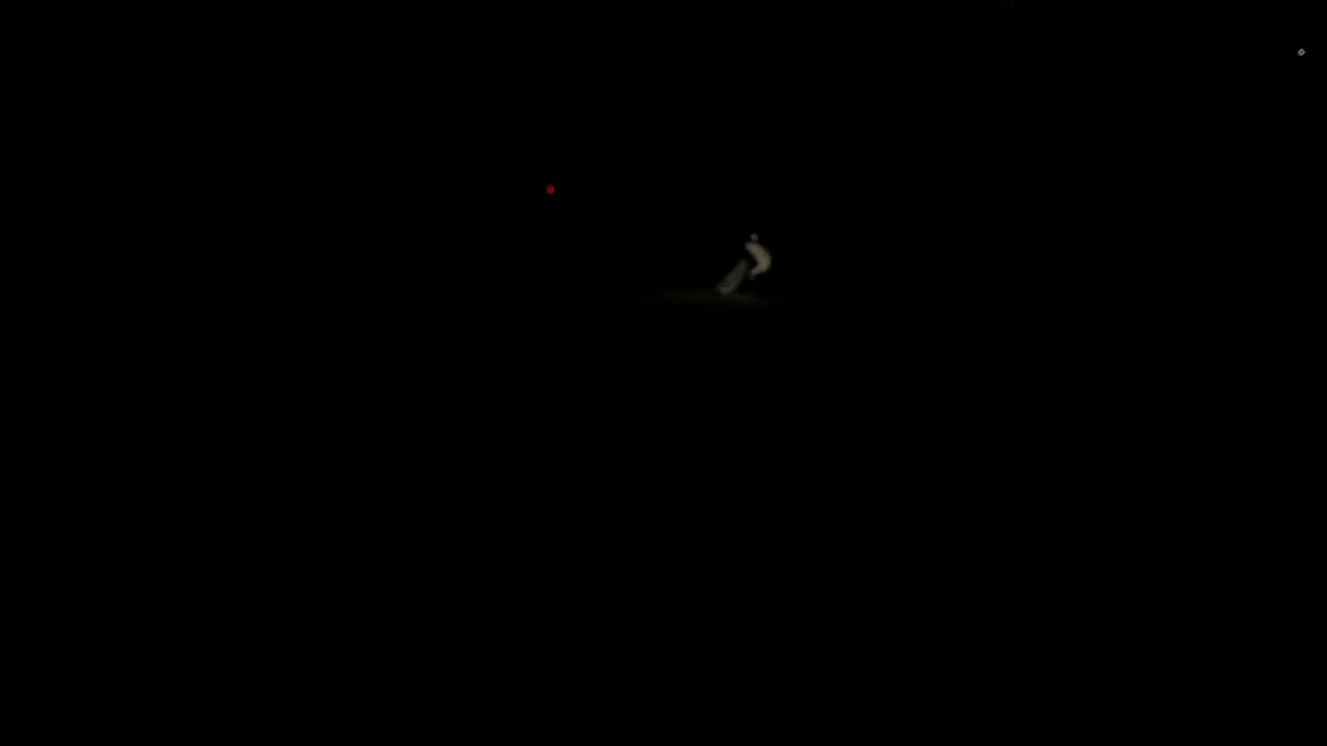 Video still: a small pale figure running in the dark