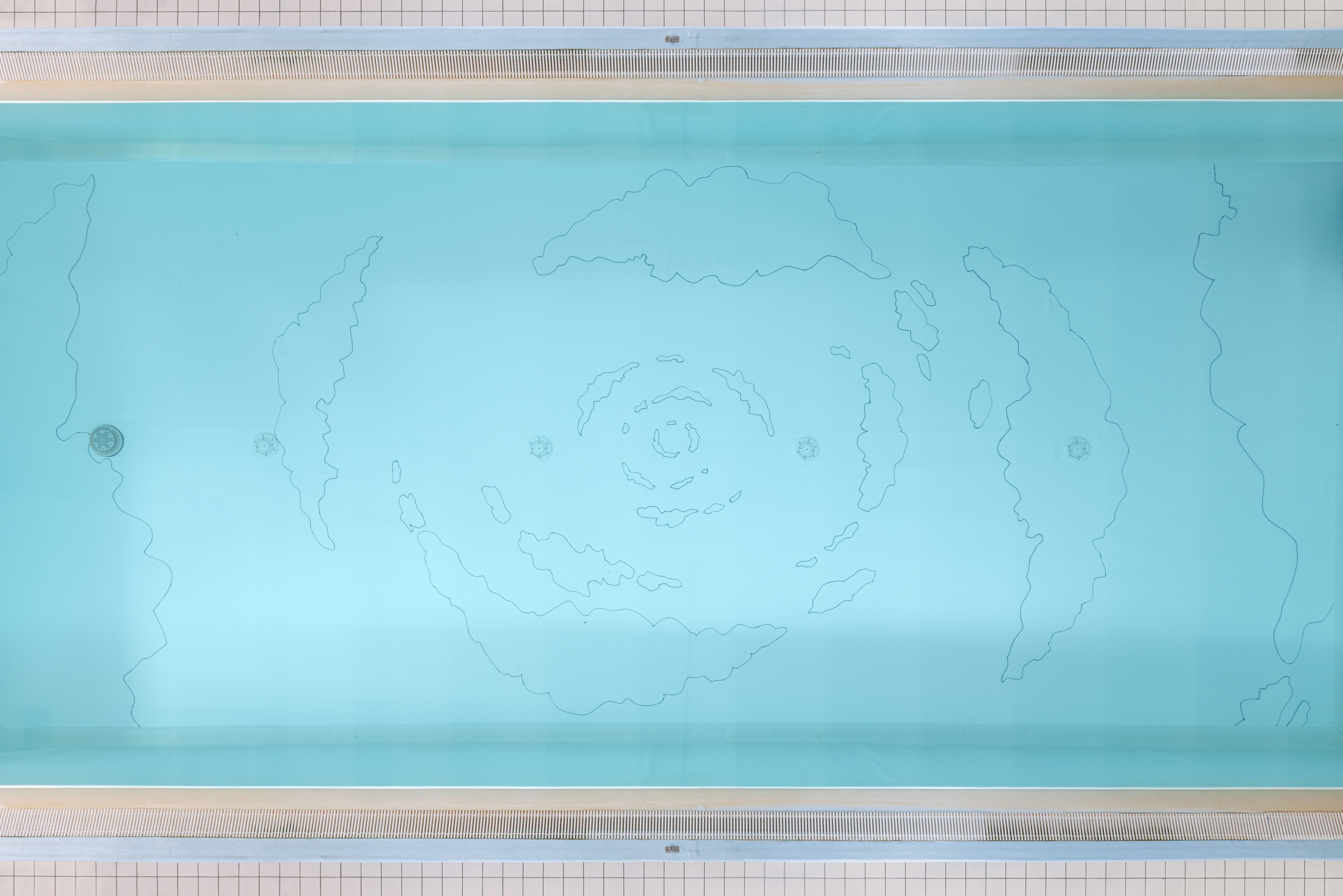 Top view of the pool with the spiral cloud drawing on its turquoise floor